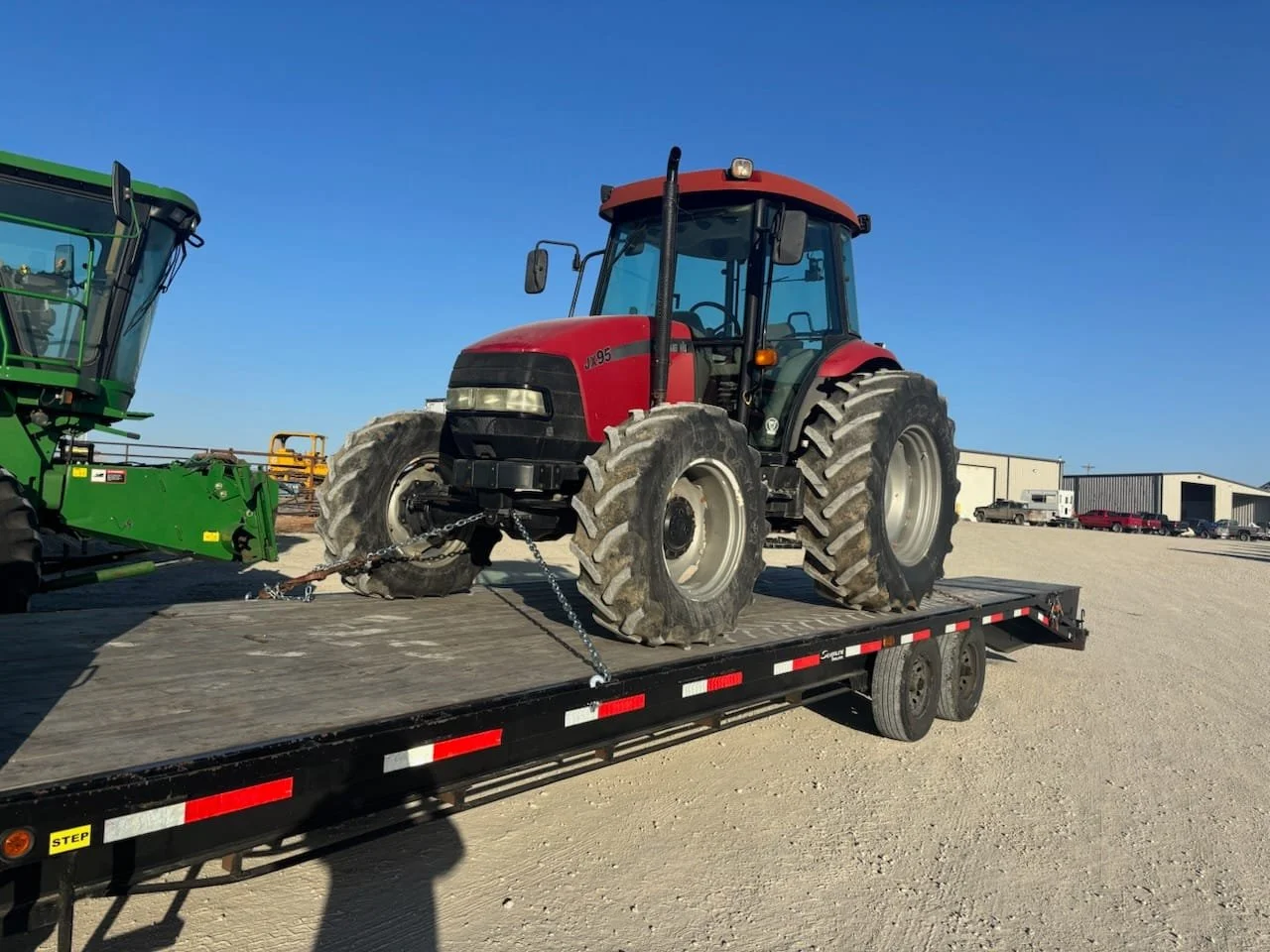Case IH tractor secured on flatbed trailer for agricultural equipment transport – Prime Load Solutions