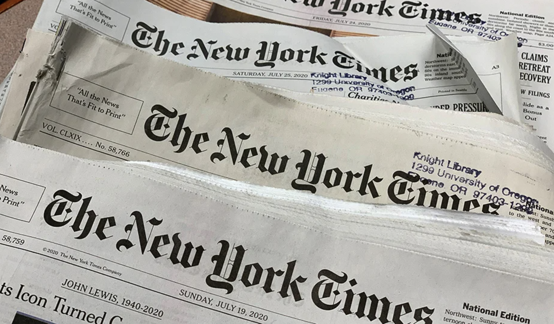 Stack of newspapers with the front page of The New York Times visible, dated Saturday, July 25, 2020.
