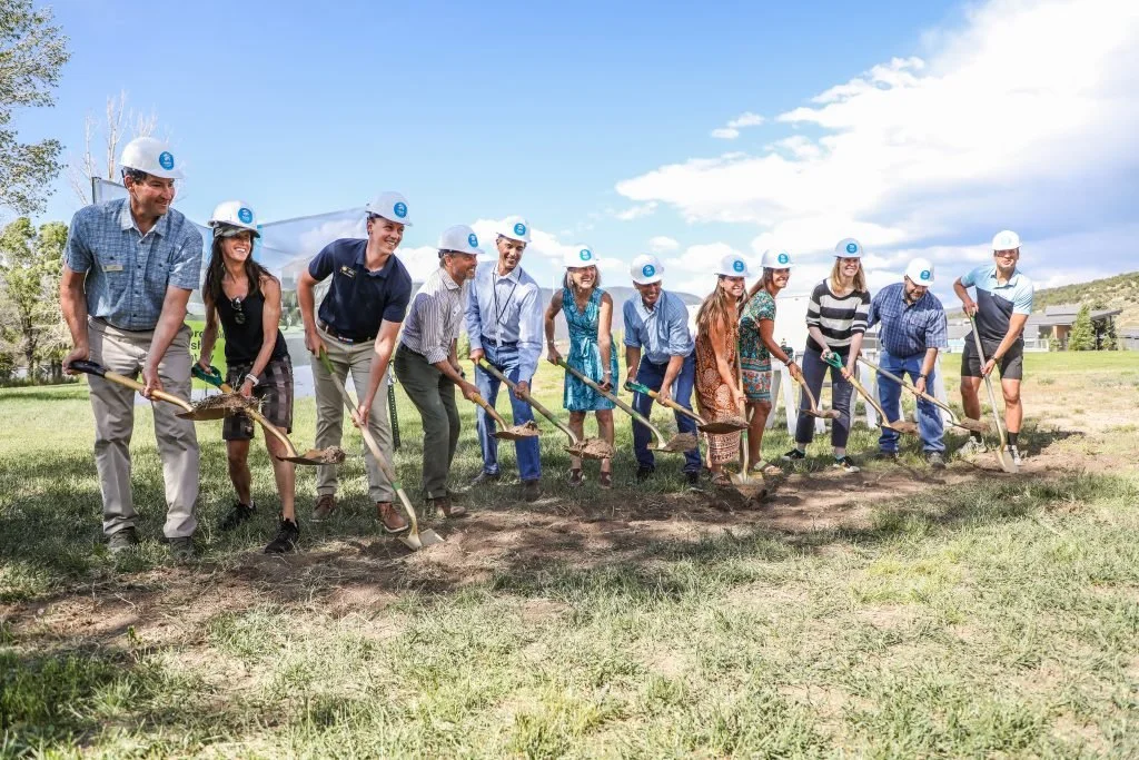 a group of people holding shovels at a Fading West workforce housing groundbreaking ceremony in Colorado 