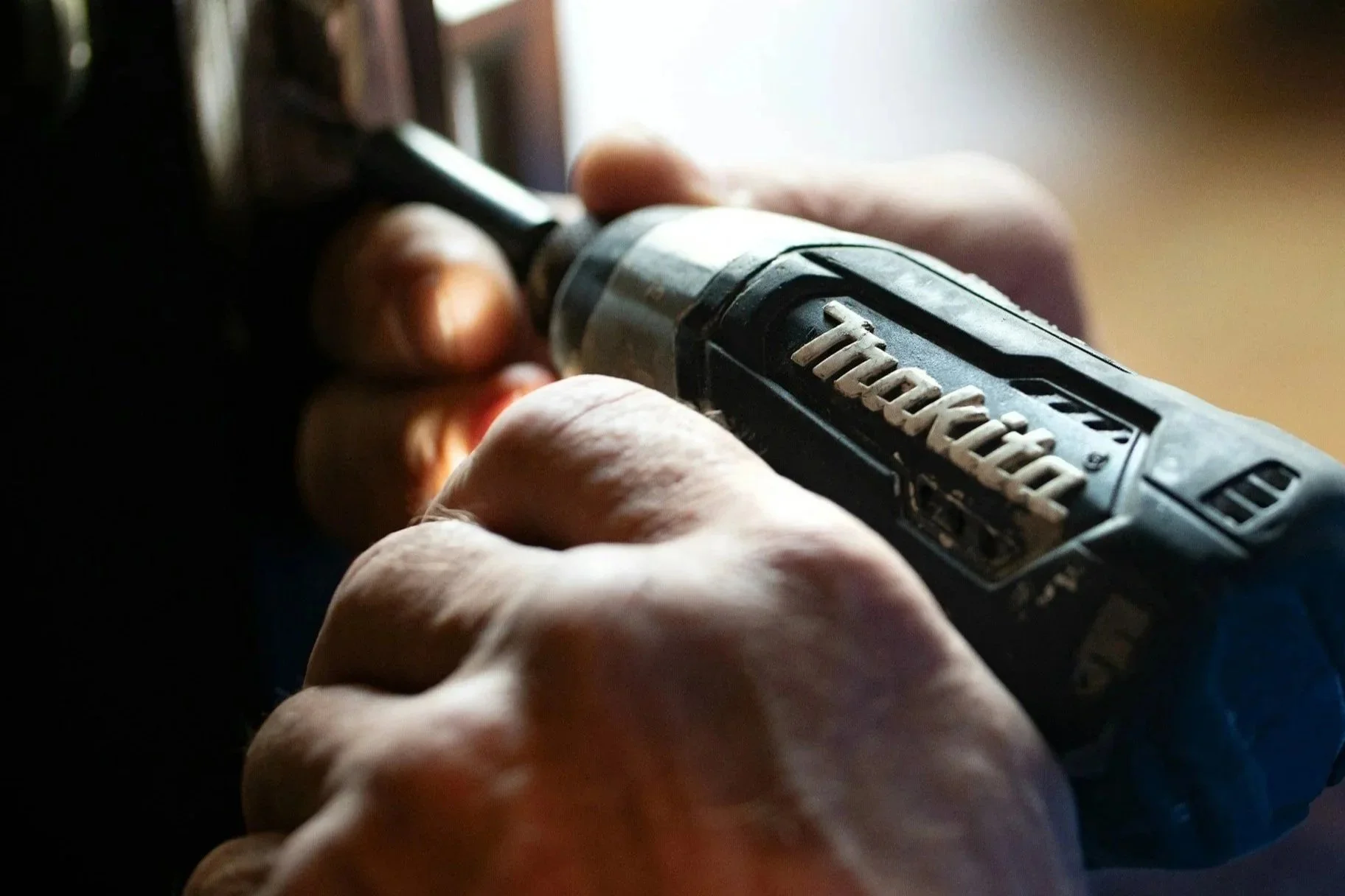 Close-up of a person's hand holding a black and gray TOOLCRAFT cordless power drill.