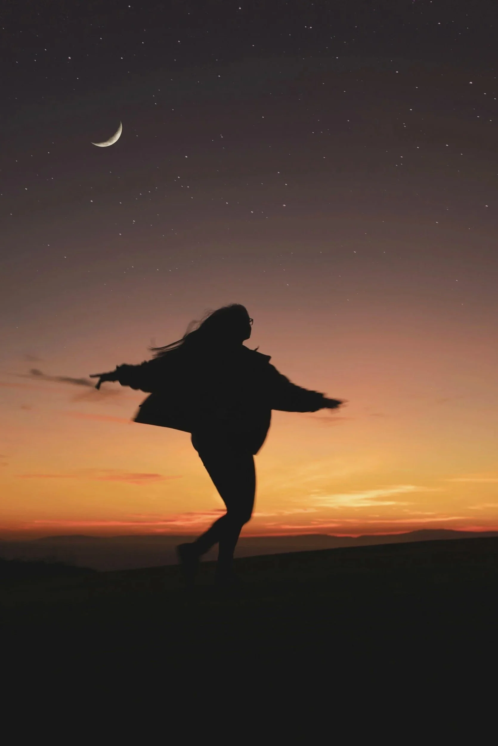 Woman with arms outstretched feeling free and at peace, representing healing from generational trauma
