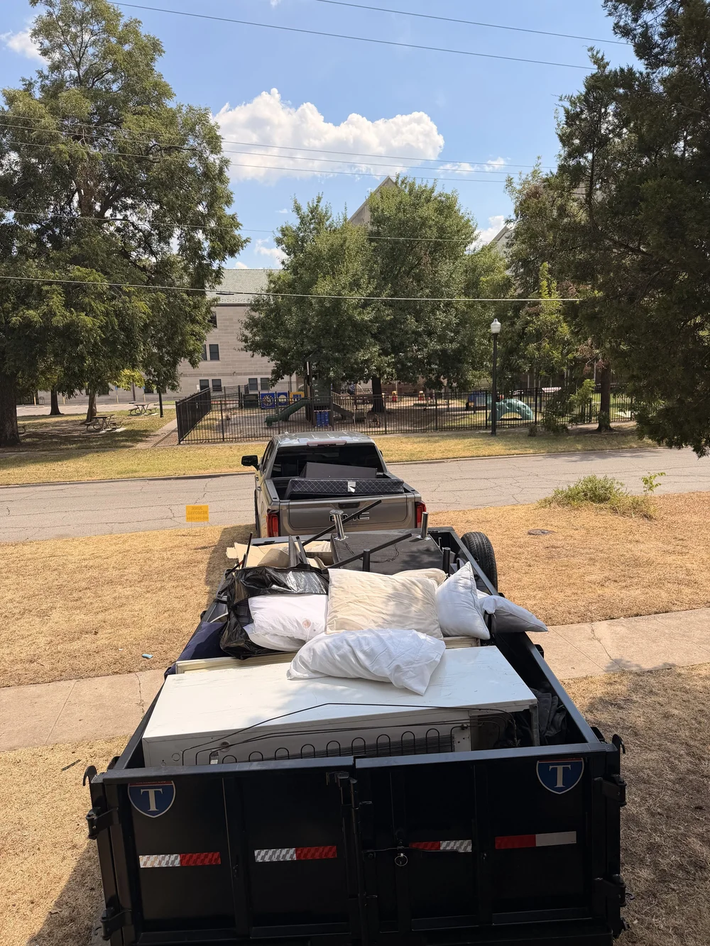 Dump trailer loaded with household junk and mattresses