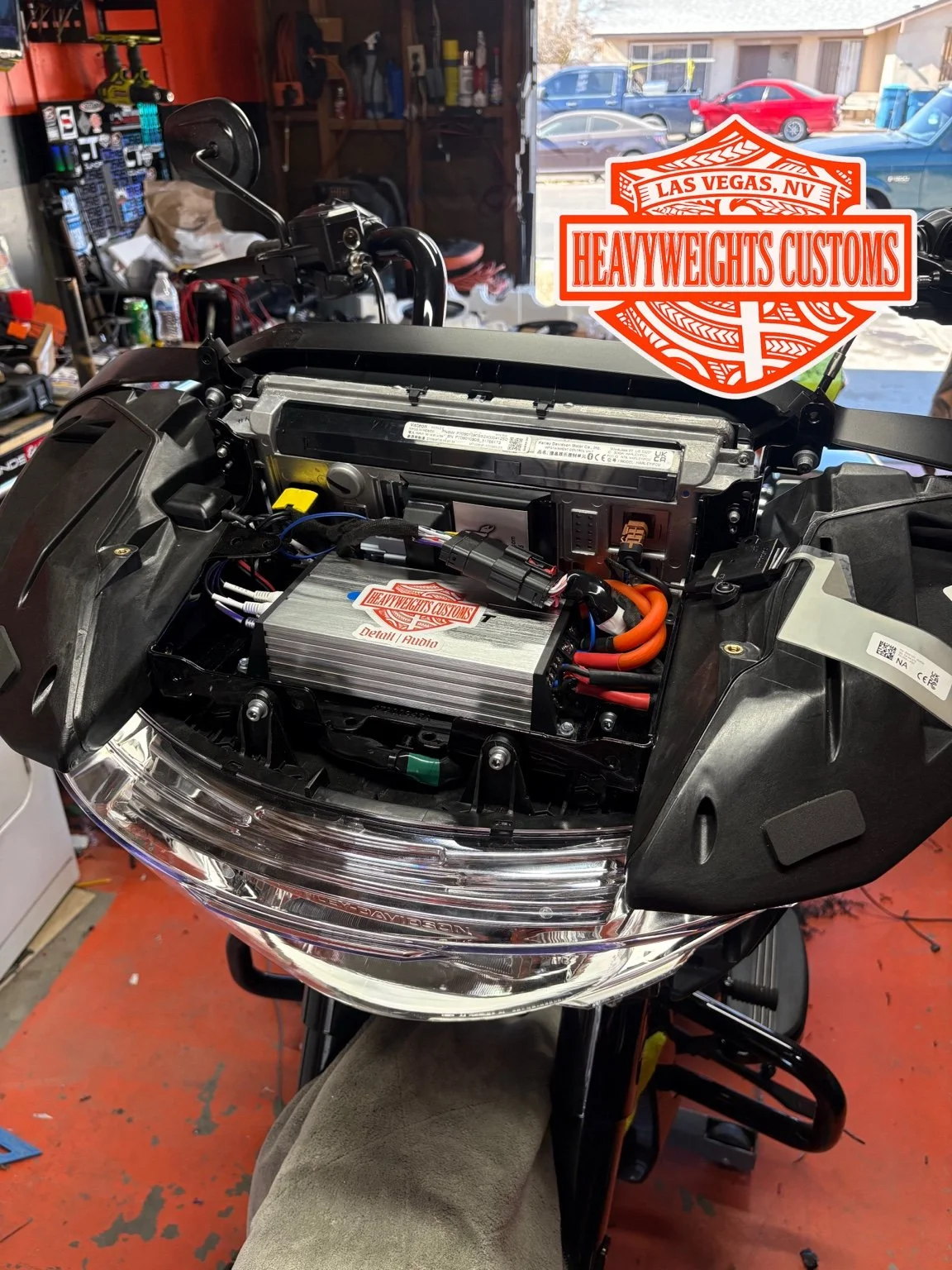 Close-up of a motorcycle's front dashboard area with audio equipment installed.