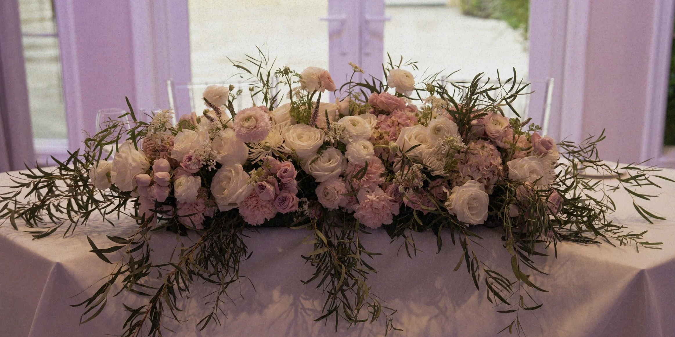 Sweetheart table for wedding ceremony with Roses, Hydrangeas, Eucalyptus & Ranunculus.