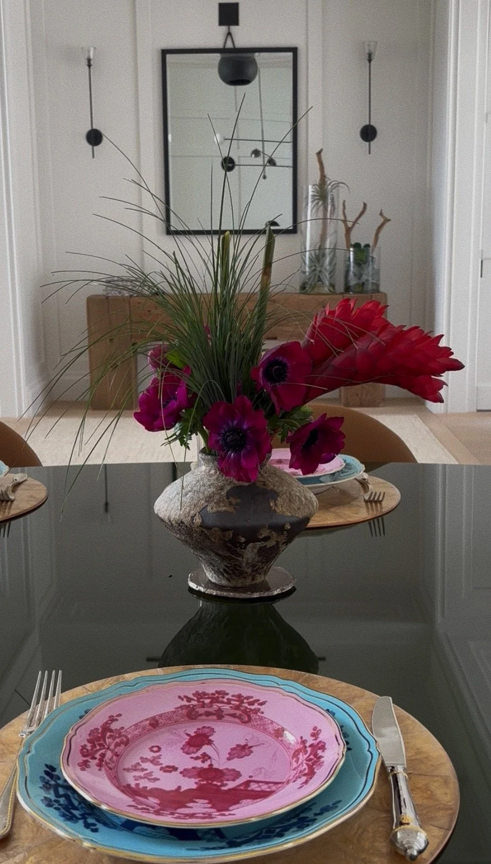 Deep purple anemones, torch ginger, and wild grass in a brutalist ceramic vase. Bold, unexpected, and entirely at home on a table set for something worth remembering.