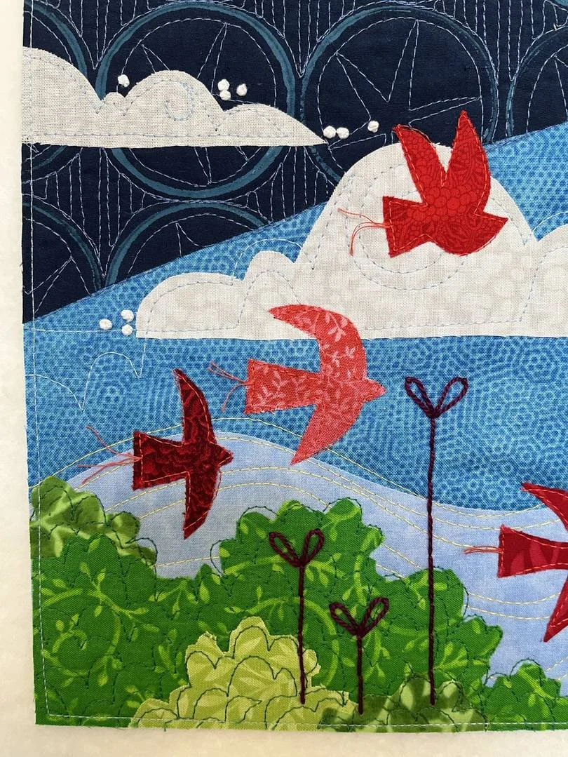 Detail view of red appliquéd birds, green tree shapes, and dark embroidered stems from Deborah Boschert's Looking Up art quilt.