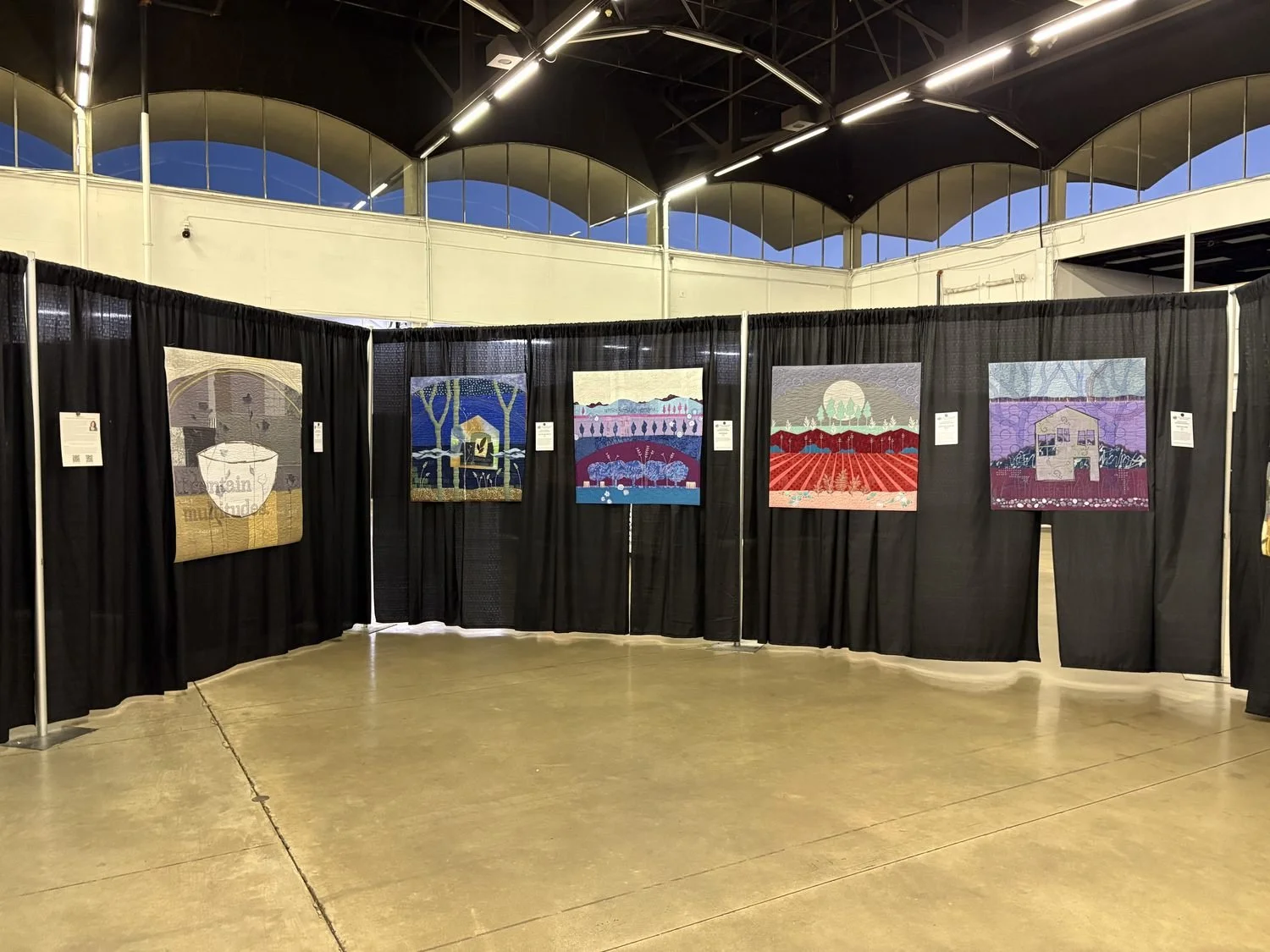 Five of Deborah Boschert's landscape art quilts and a bowl-themed quilt displayed at the Dallas Quilt Show.