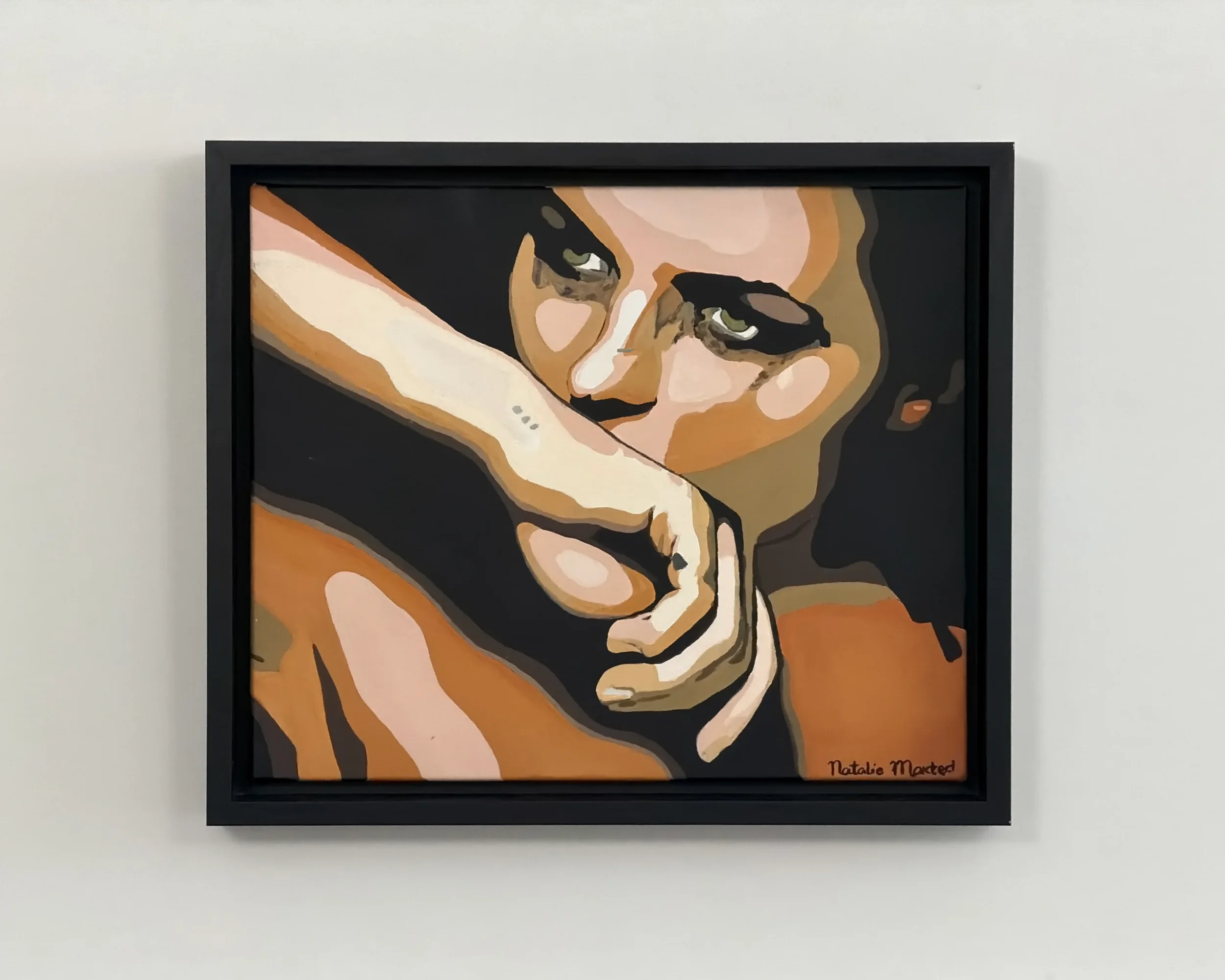 A framed artwork of a woman's face resting her head on her arm, with expressive eyes and dark hair. The artwork is in a stylized, abstract style with warm tones. The artist's signature, Natalie Mander, is visible in the bottom right corner.