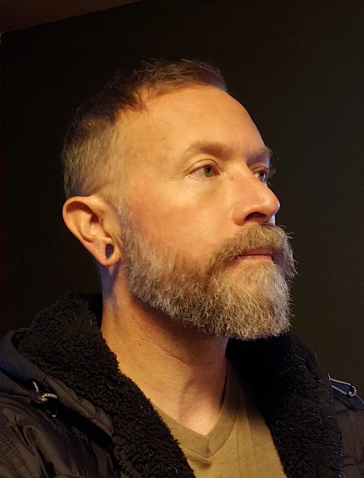 Side profile image of Bryan Lindquist LMT, dark background.