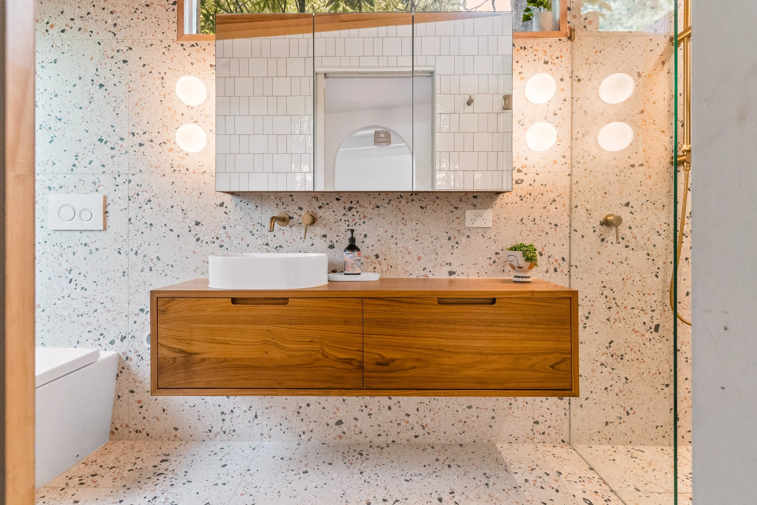 Modern bathroom with terrazzo tile walls and floor, wooden vanity with built-in sink in Yarra Valley built by Leisure Built