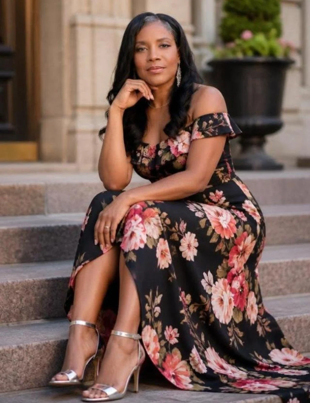 Wendy Y. Norman, founder of The Secret Place Press, is seated outdoors wearing a floral off-the-shoulder dress.