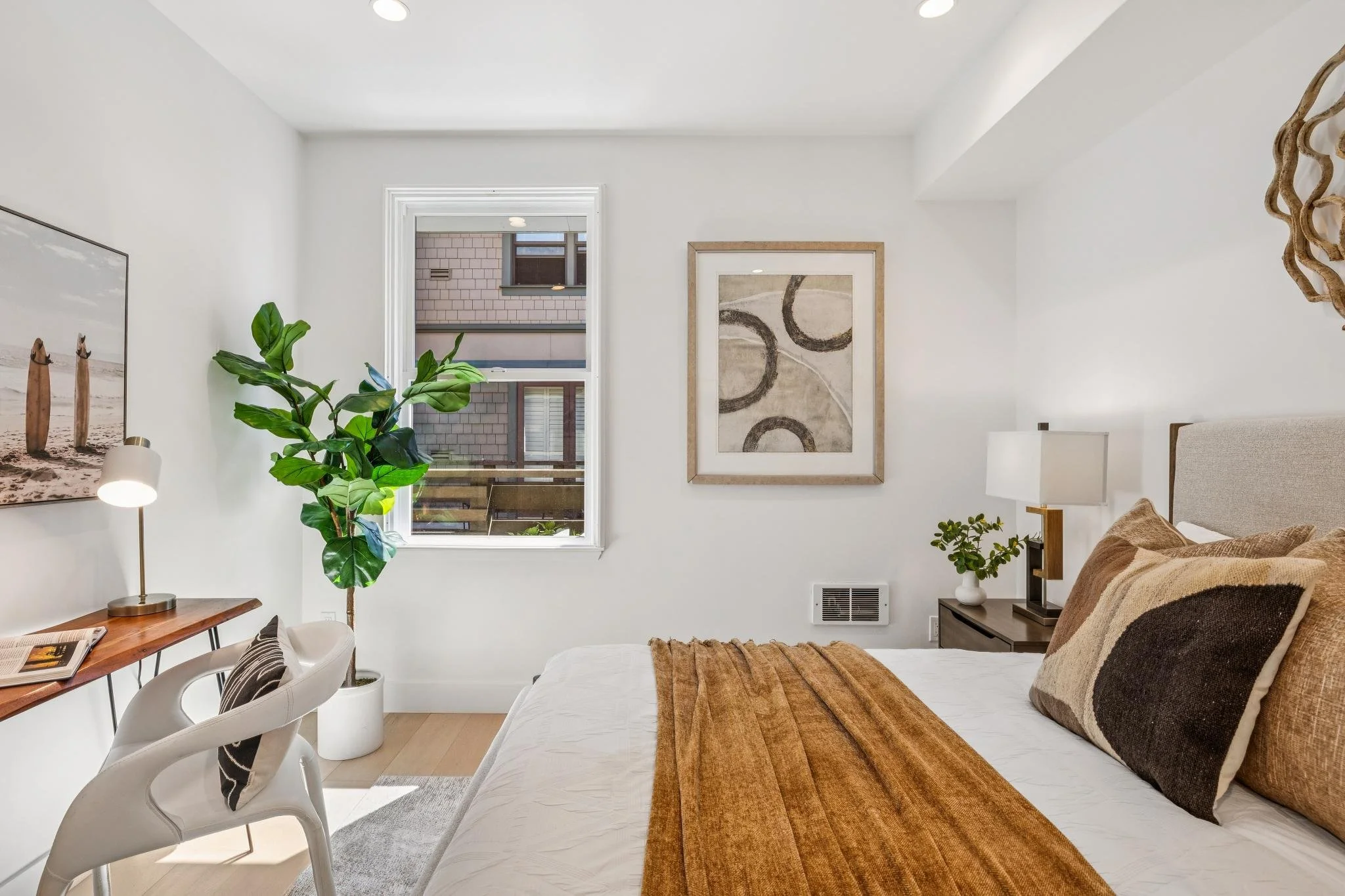 Modern kitchen with dark wood cabinets, a granite island with a sink, two white barstools, and stainless steel appliances including a microwave, overhead lighting, and pendant lights.