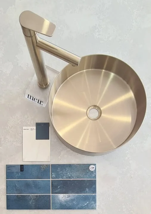 A stainless steel sink with a modern faucet, sample color swatches, and a color palette placement on a light-colored surface.
