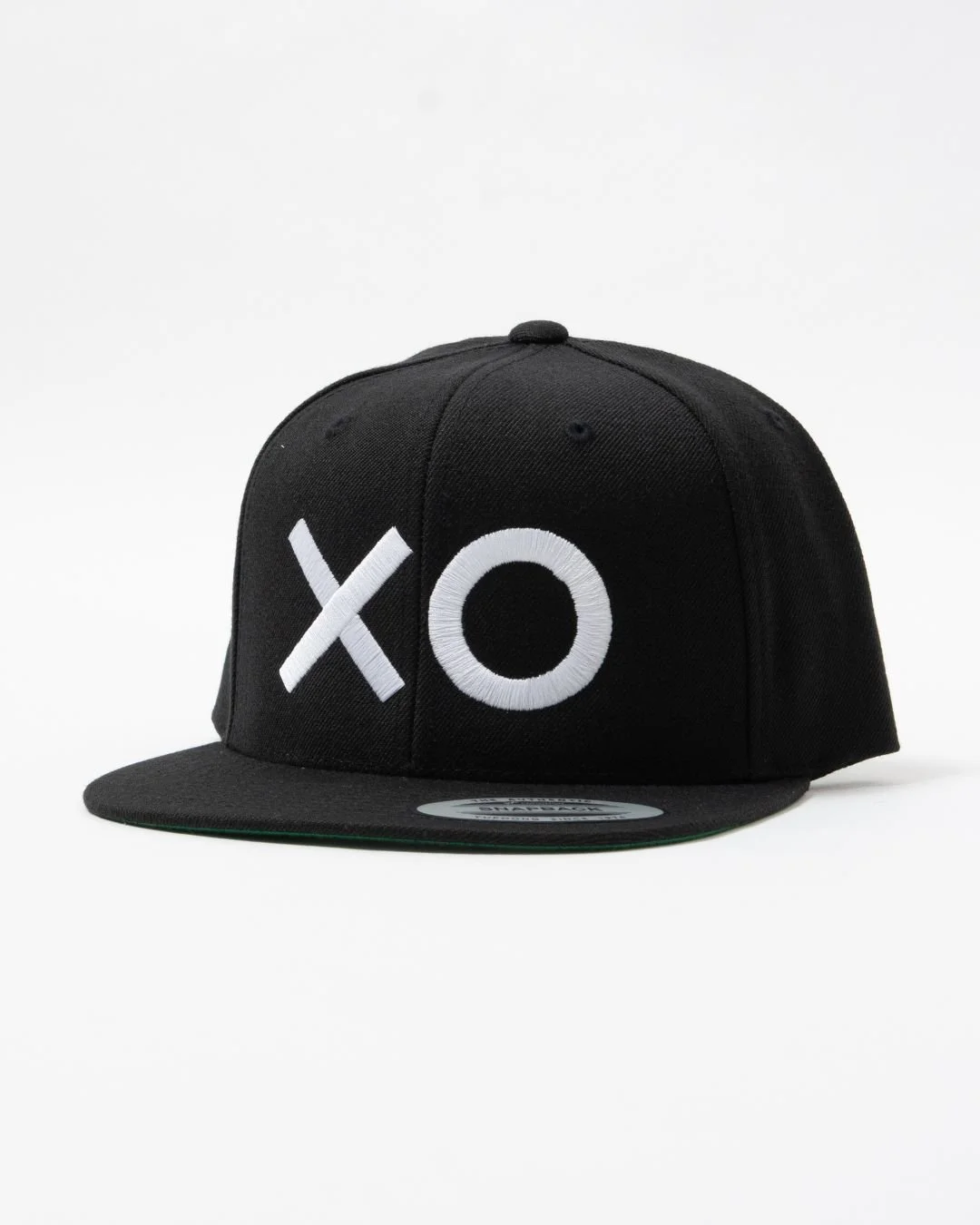 Black baseball cap with white embroidered XO logo on front, sitting on a white background.