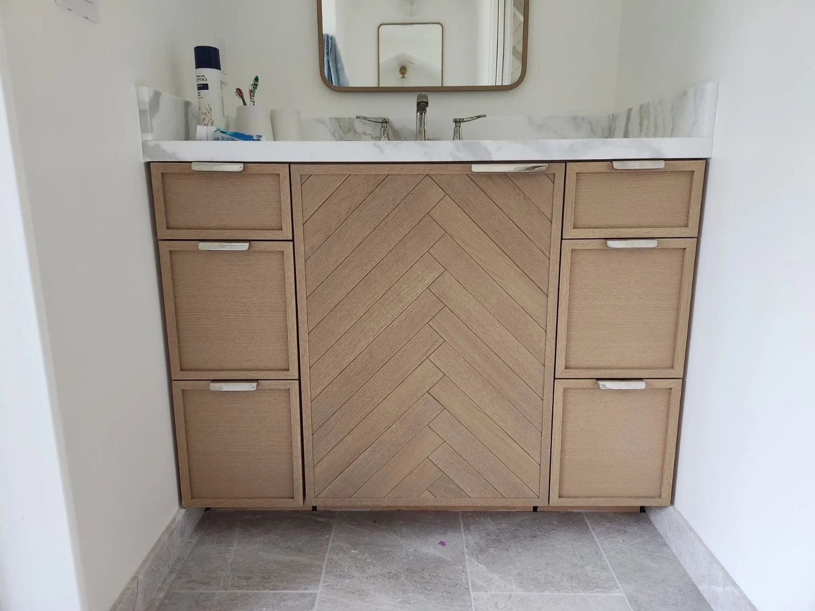 Custom wood bathroom vanity with angular wood designs and inlays