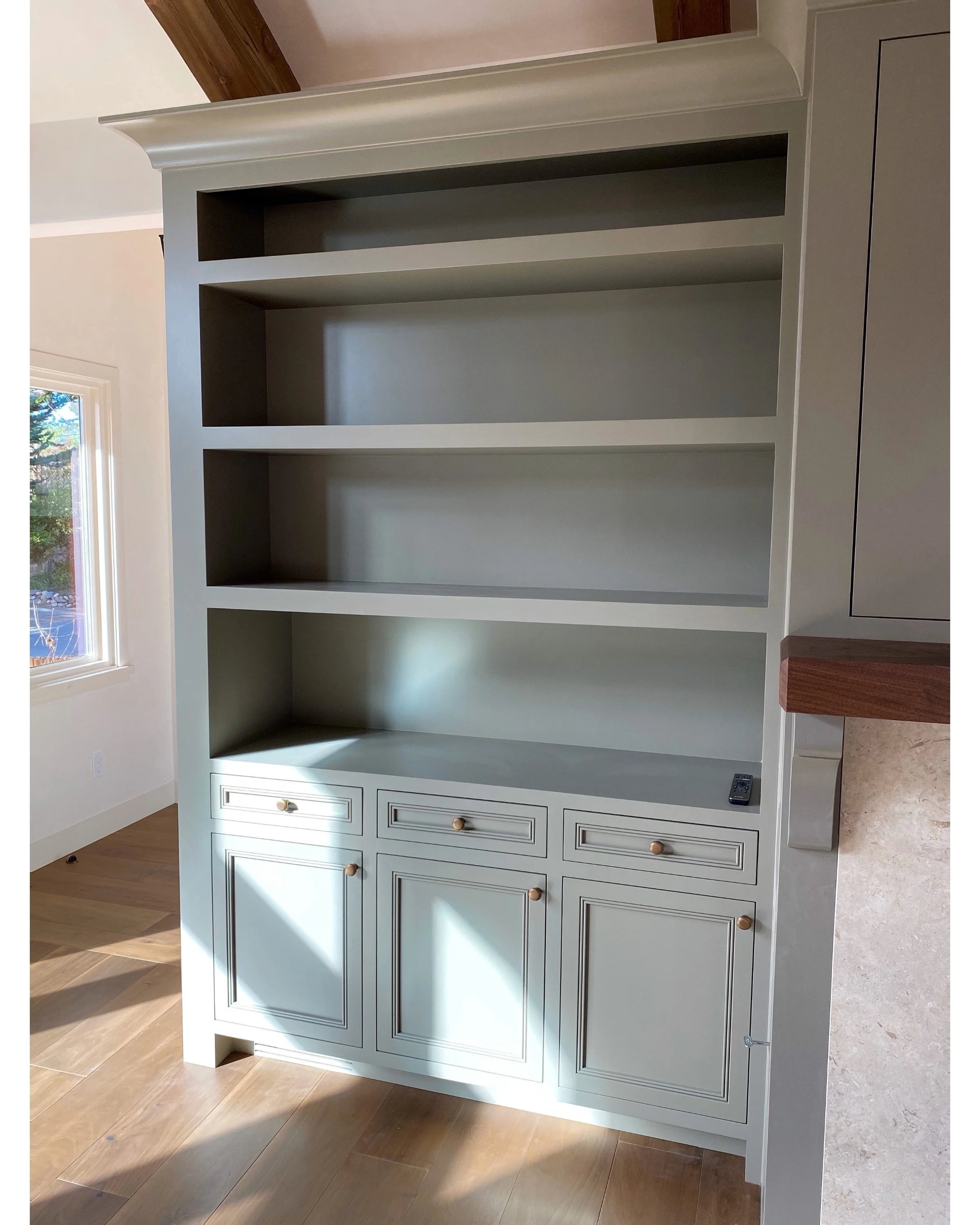 Custom bookshelf and cabinet built-ins in a teal color created by Valley Mill Shop