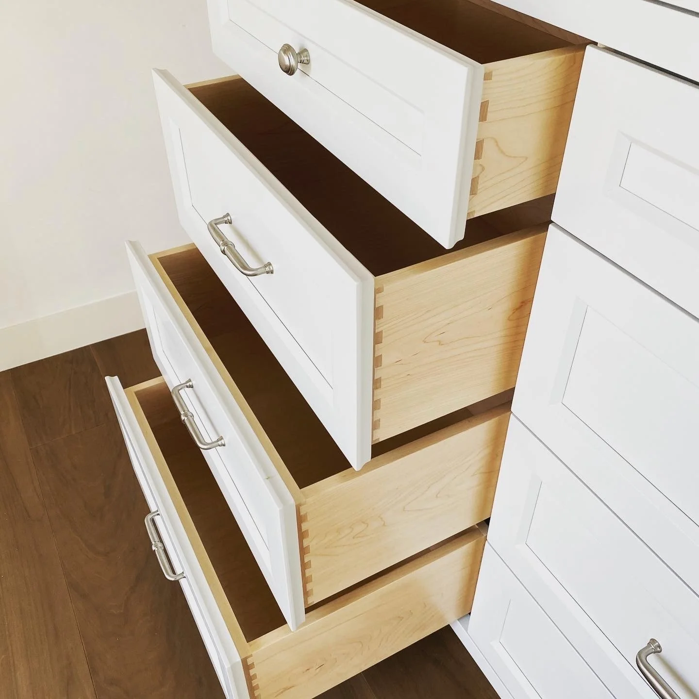 Custom cabinets built in Monterey, California with silver handles and white paint. Custom dovetail joining on the drawers
