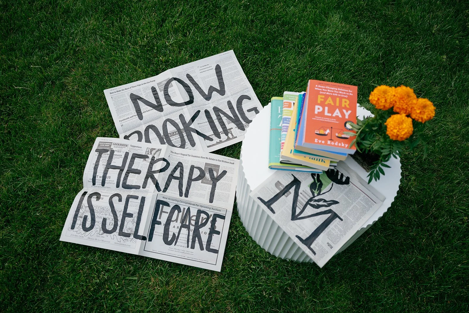 Newspapers, books, Marigold logo on grass