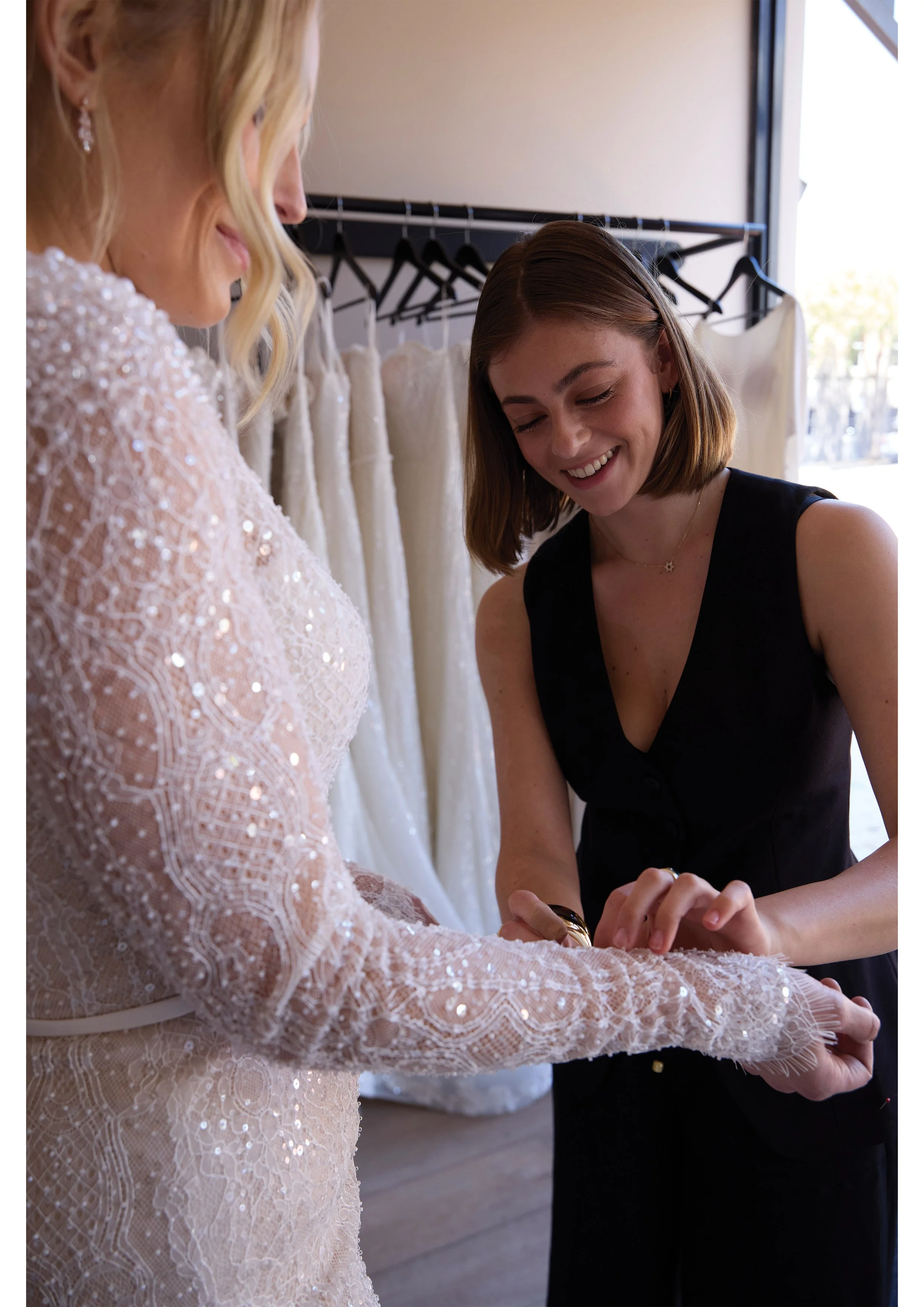 bridal designer and stylst dresses bride at bridal boutique in Melbourne wearing long sleeve wedding dress with beading