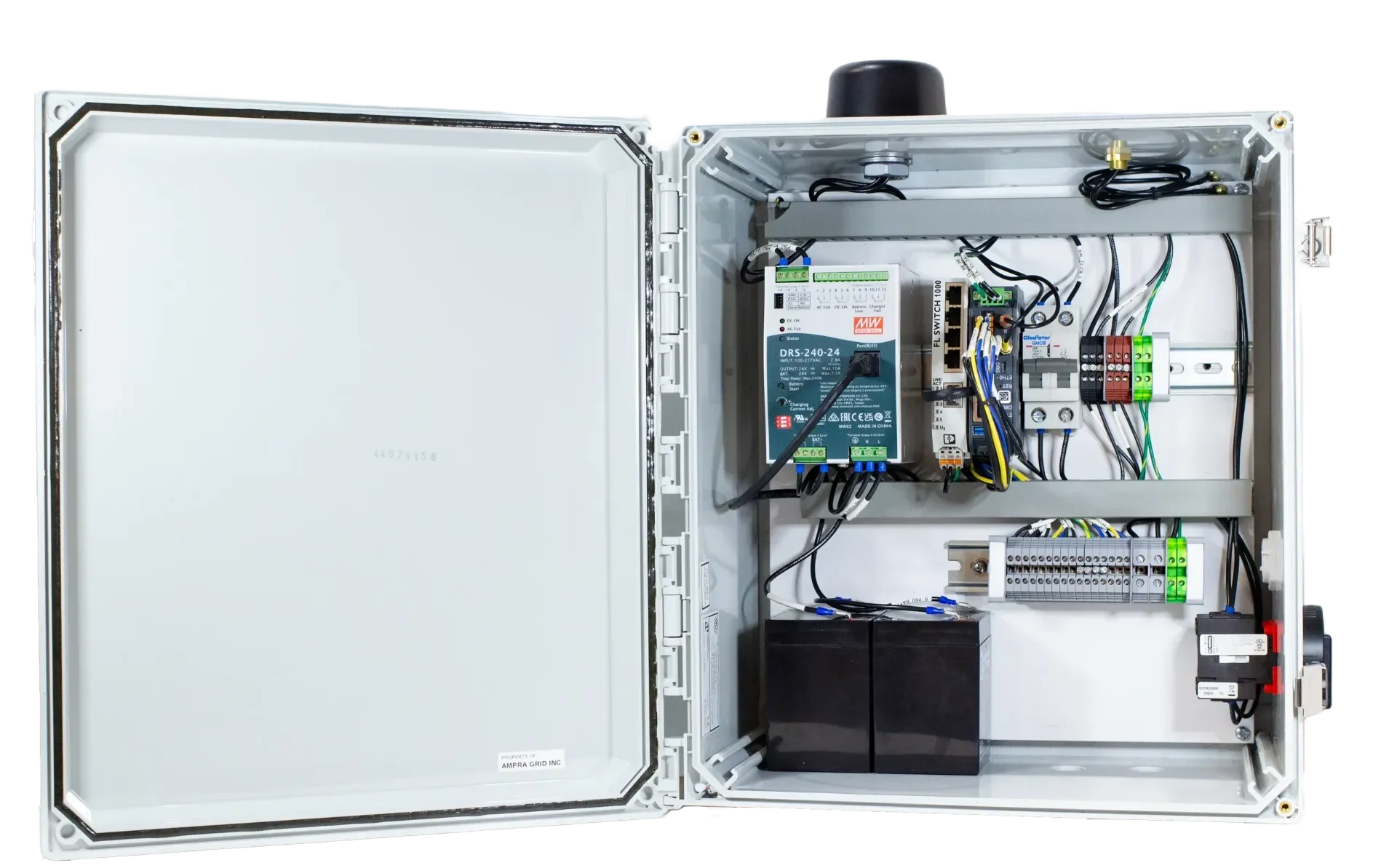 Open electrical control box with components including a circuit board, wiring, and a black battery inside a white enclosure.