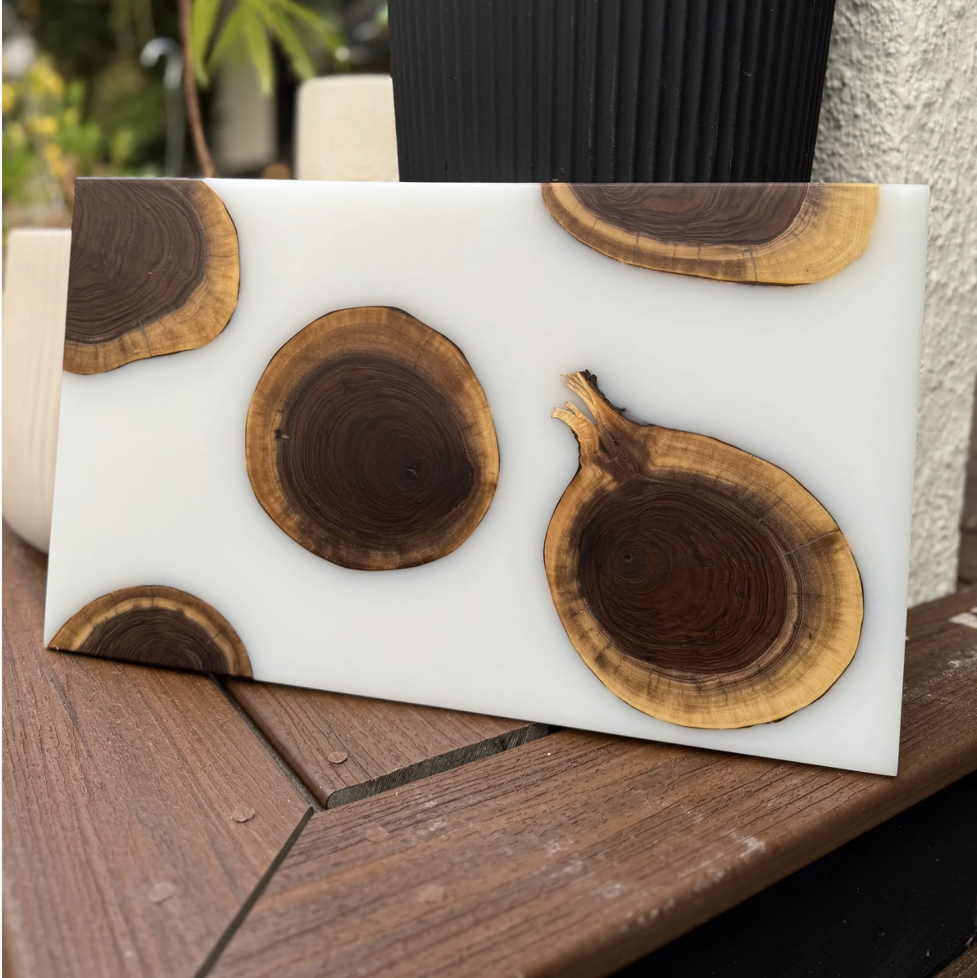 White decorative item with embedded wooden slices resting on a wooden surface.
