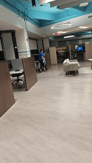 Recepción o área de espera en una clínica u oficina, con escritorios, sillas y una pantalla de TV, con una decoración moderna y techos decorativos de color azul.