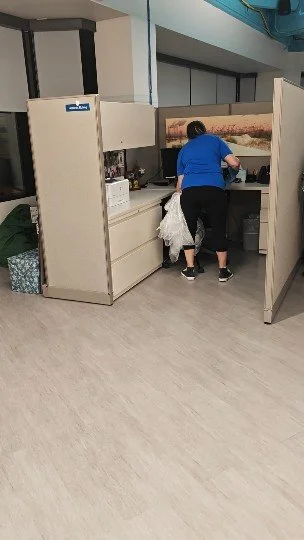 Dos personas en una oficina, una adulta y una niña, revisando documentos o productos en una mesa de trabajo.