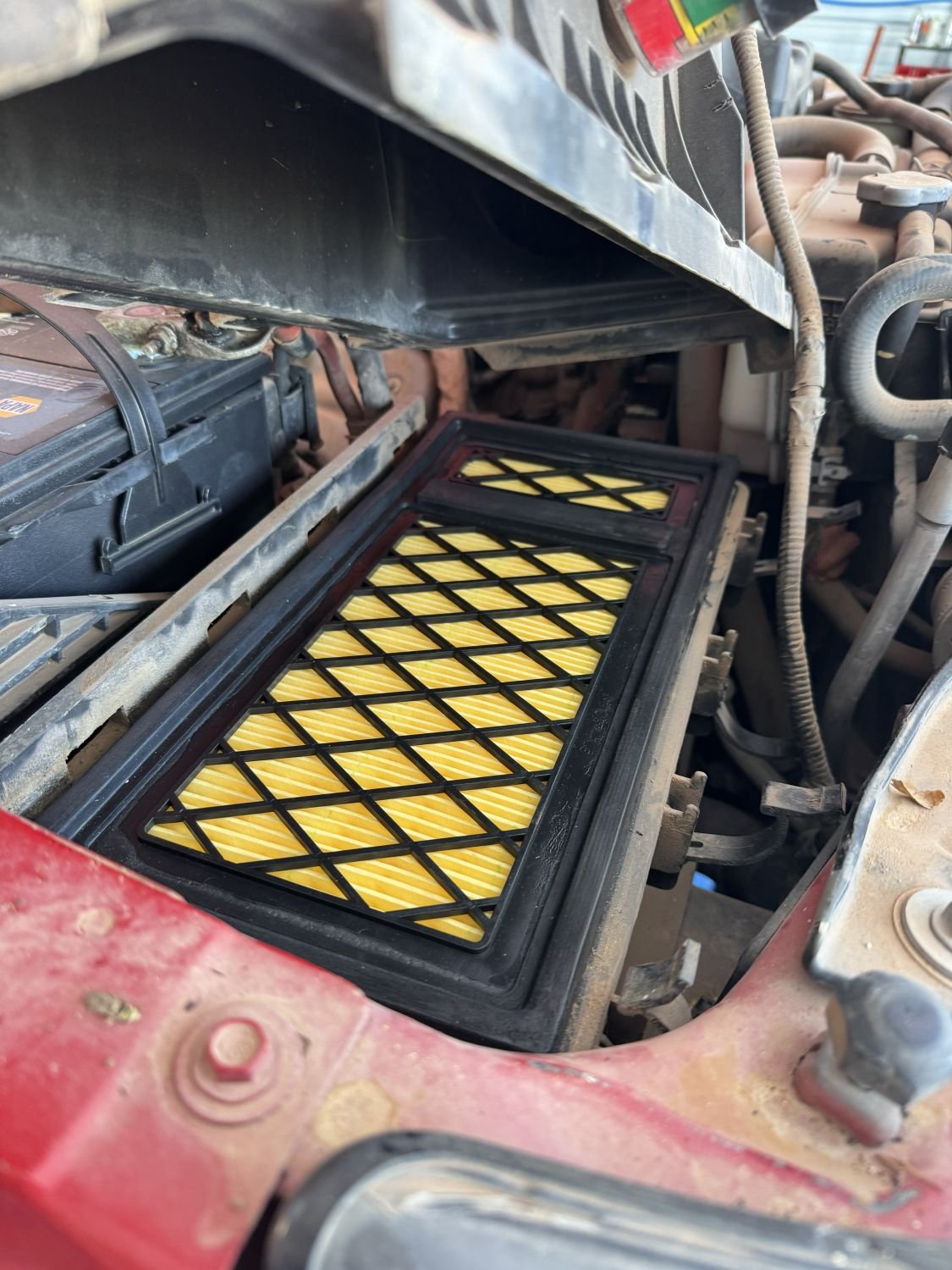 Car engine with a new yellow air filter installed.