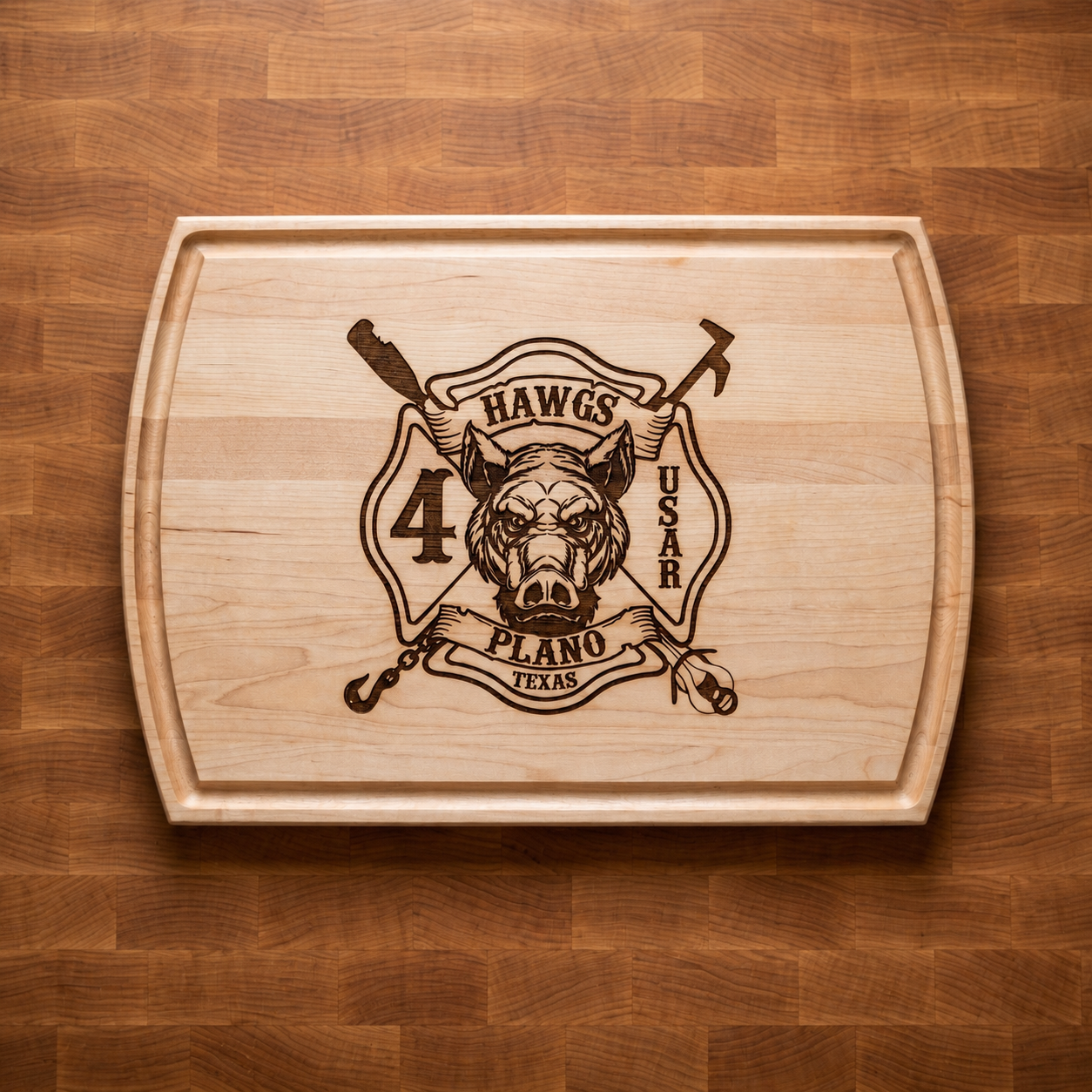 A wooden cutting board featuring a black engraved logo with a fierce dog's face, crossed pickaxe and shovel, and text saying 'H awgs,' 'PLANO Texas,' '4 U S A R.'