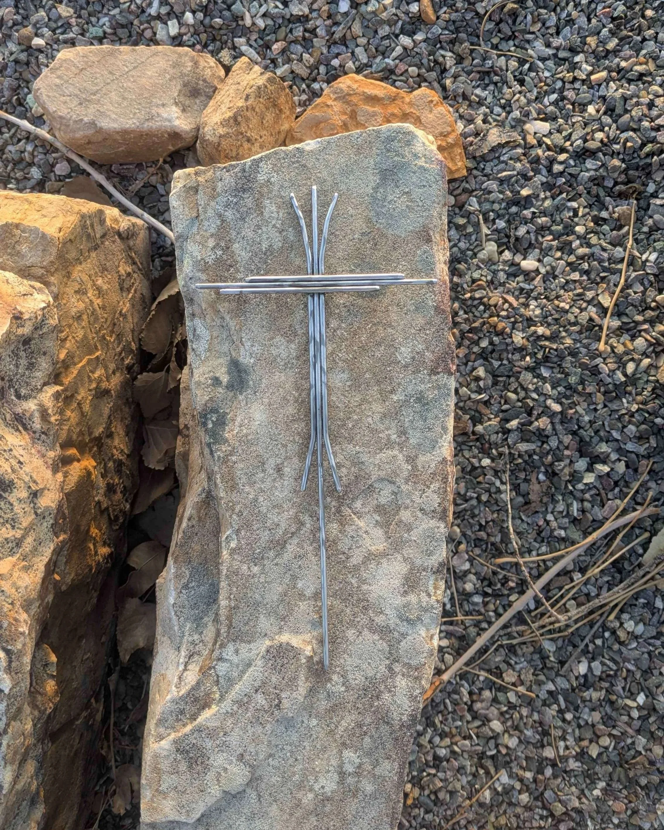 A metal art cross welded together with pieces of carefully bent metal rods.