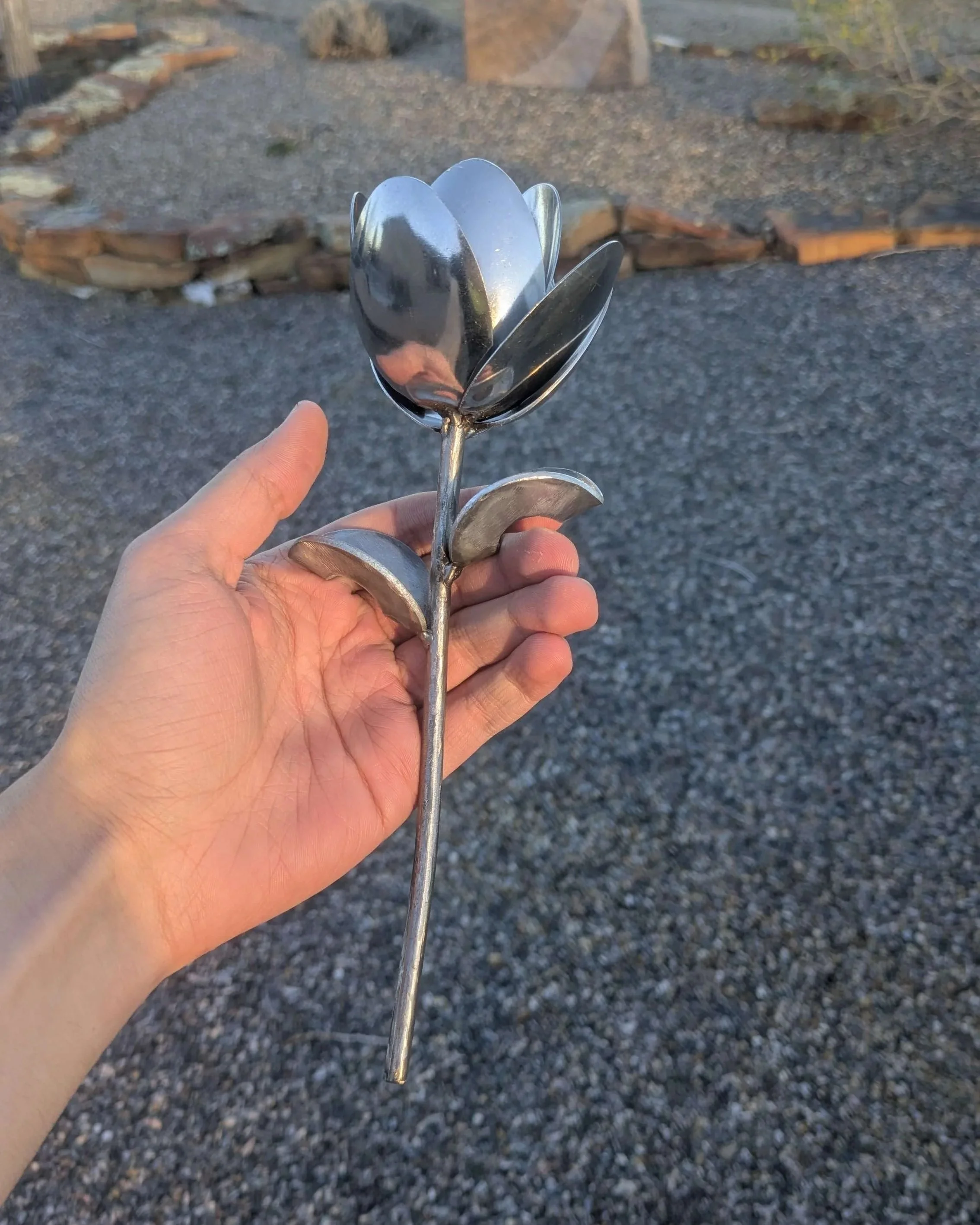 A  handmade metal art flower made from silverware, great for home decoration or as a special gift.