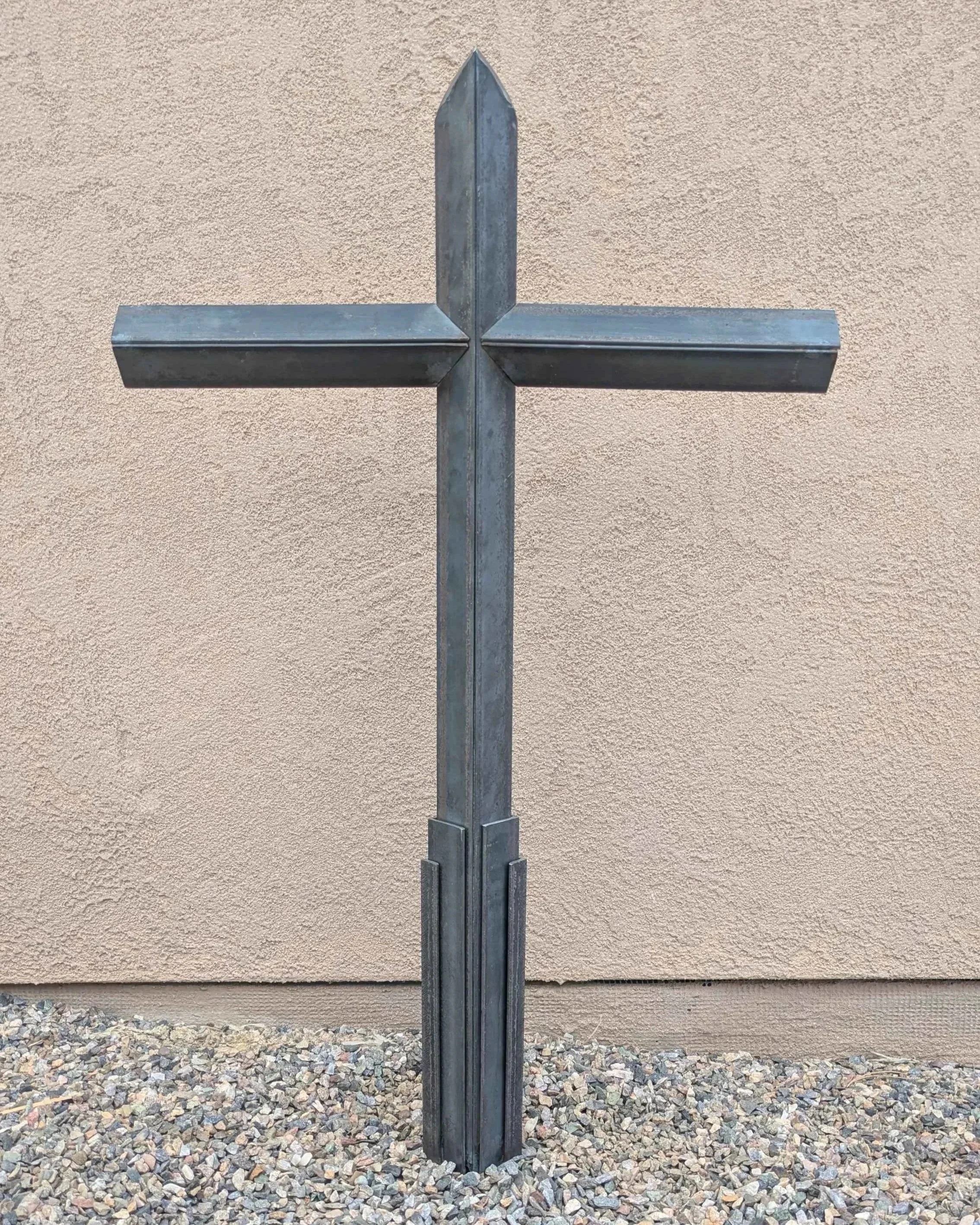 A large metal art cross sculpture made from carefully layered angle iron, designed to be a yard decoration.