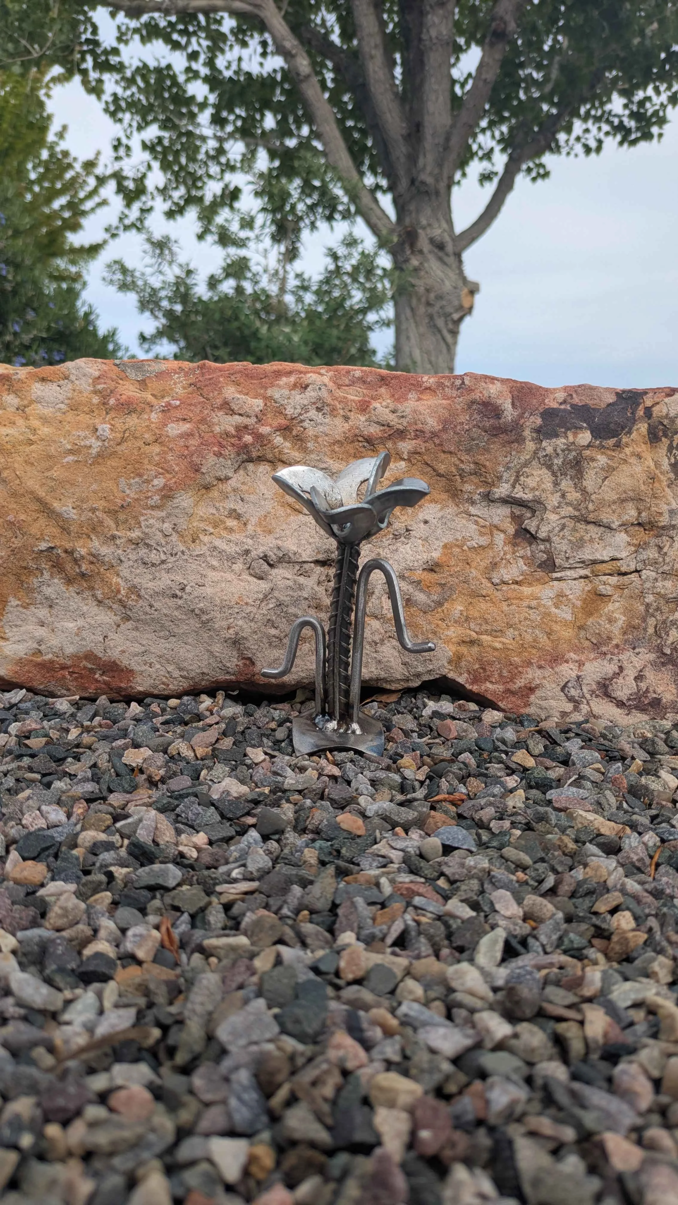 A metal art flower made in an industrial style with rebar and washers.