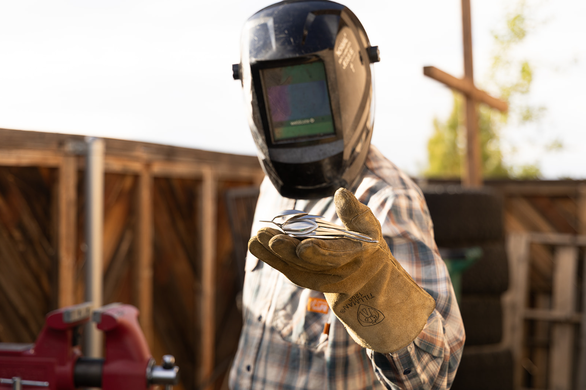 A welder holding a silverware bird