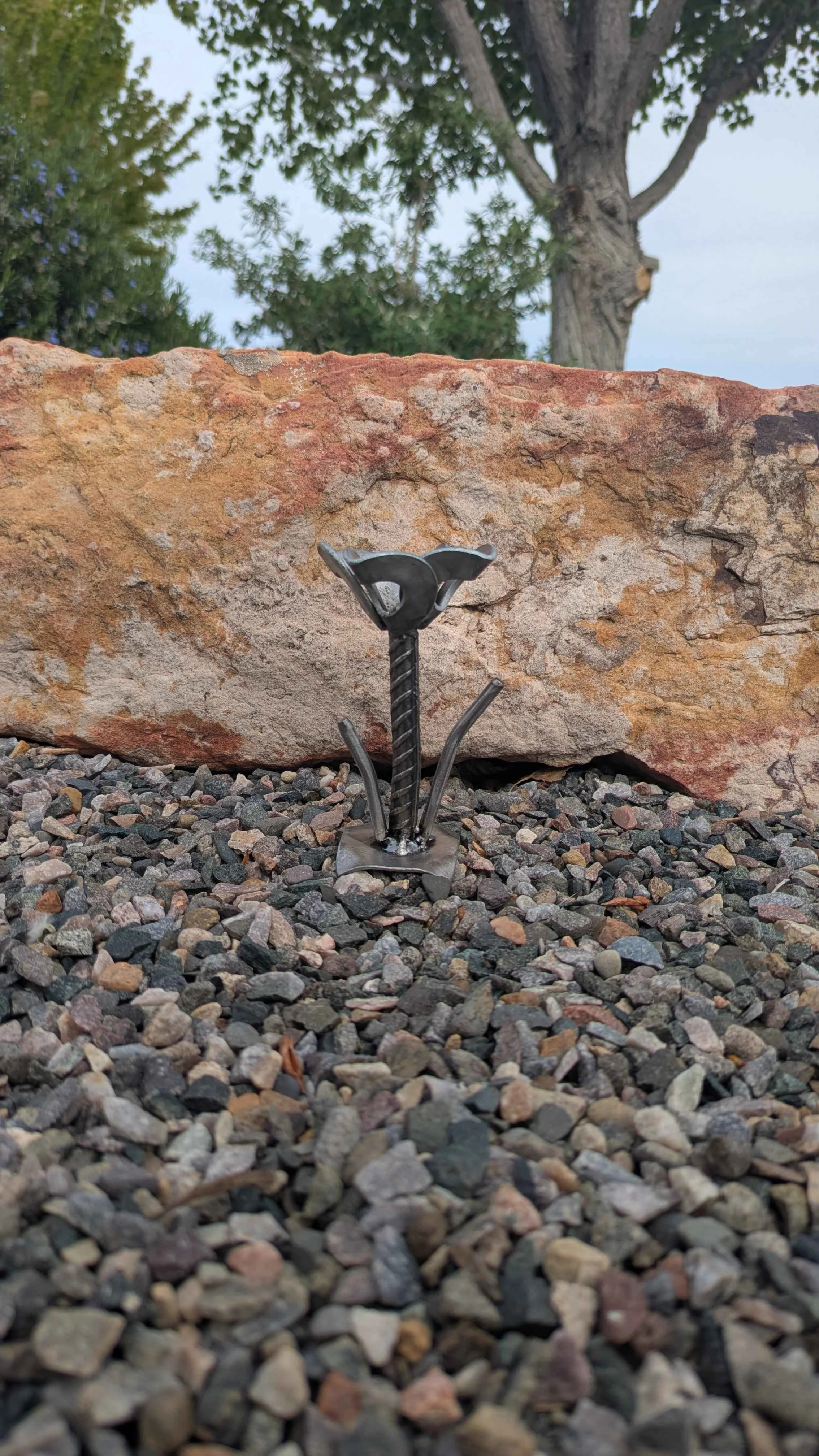 A metal art flower made in an industrial style with rebar and washers.