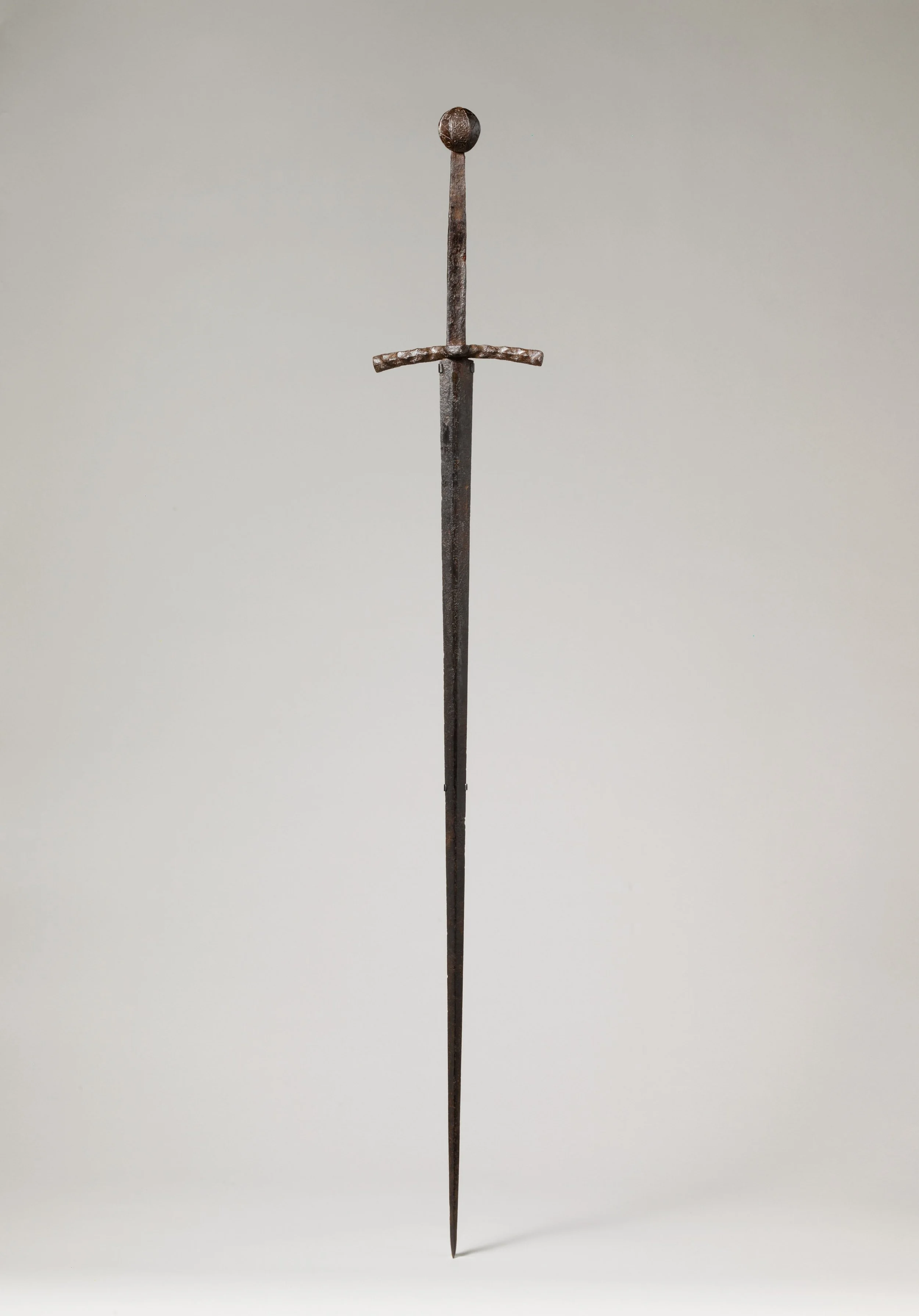 A medieval longsword with a black blade, a rounded pommel, and a crossguard, set against a plain light gray background.