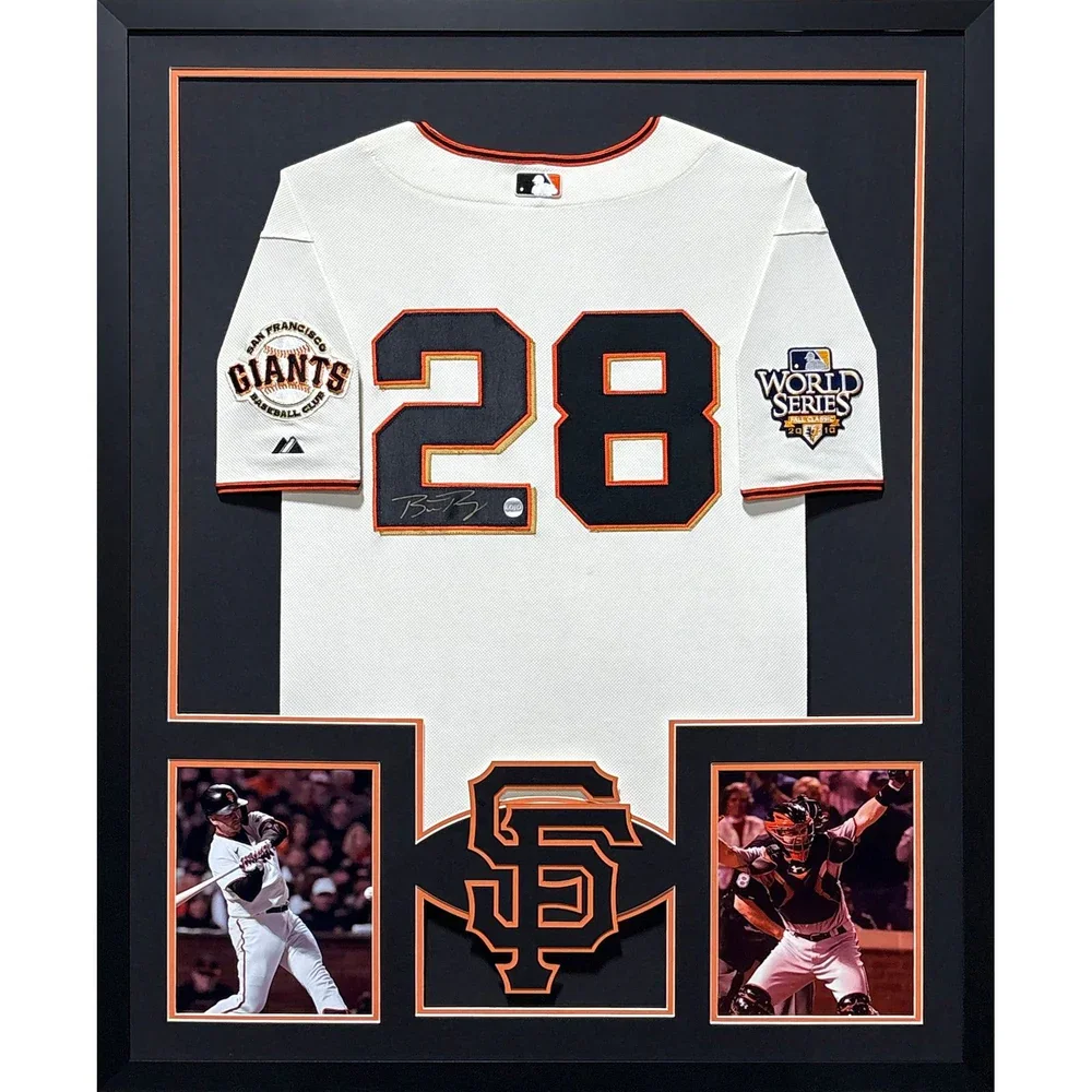 Framed San Francisco Giants signed baseball jersey with patch celebrating the 2014 World Series, flanked by photos of a player batting and a catcher in gear, and a large SF logo at the bottom center.