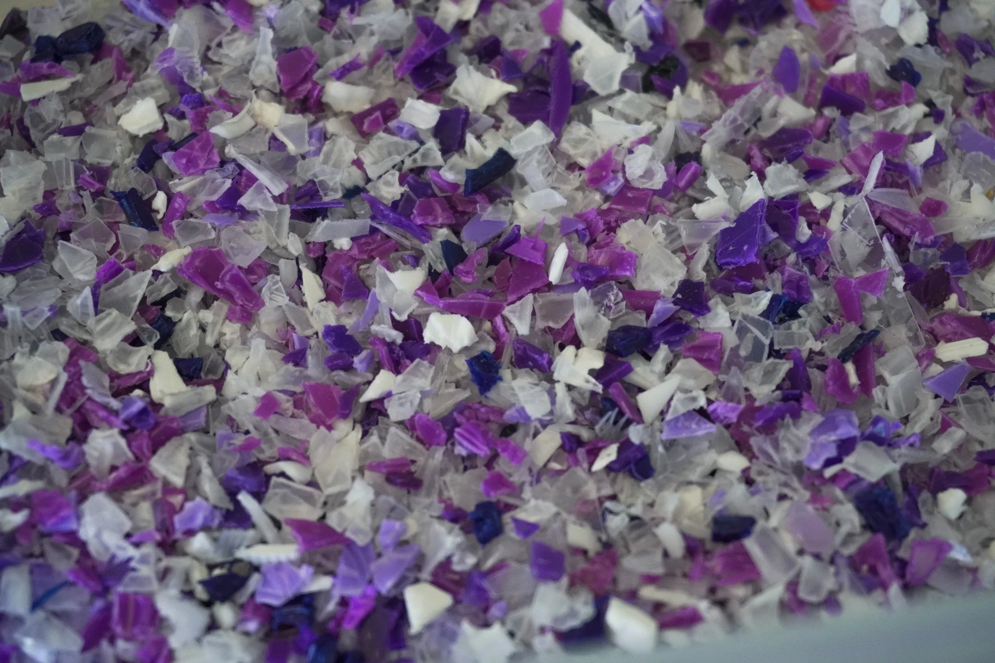 Close-up of multicolored shredded paper in shades of purple, white, and black.