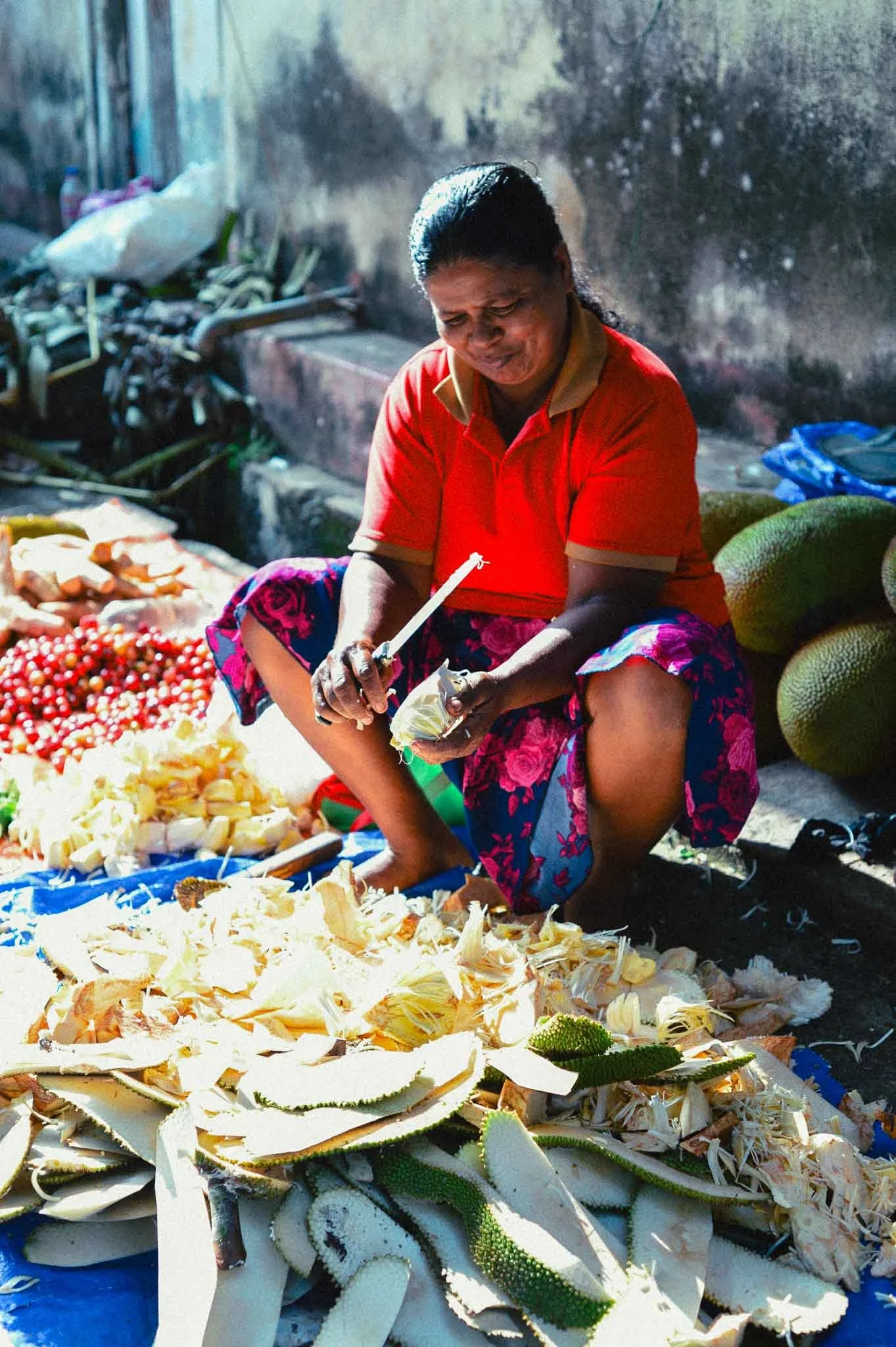 a women cutting jack fruits at weligama market