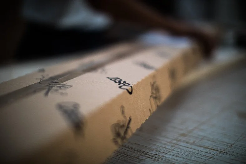 Nahaufnahme eines Papierstreifens mit der Aufschrift »Design«, auf einem Tisch liegend.