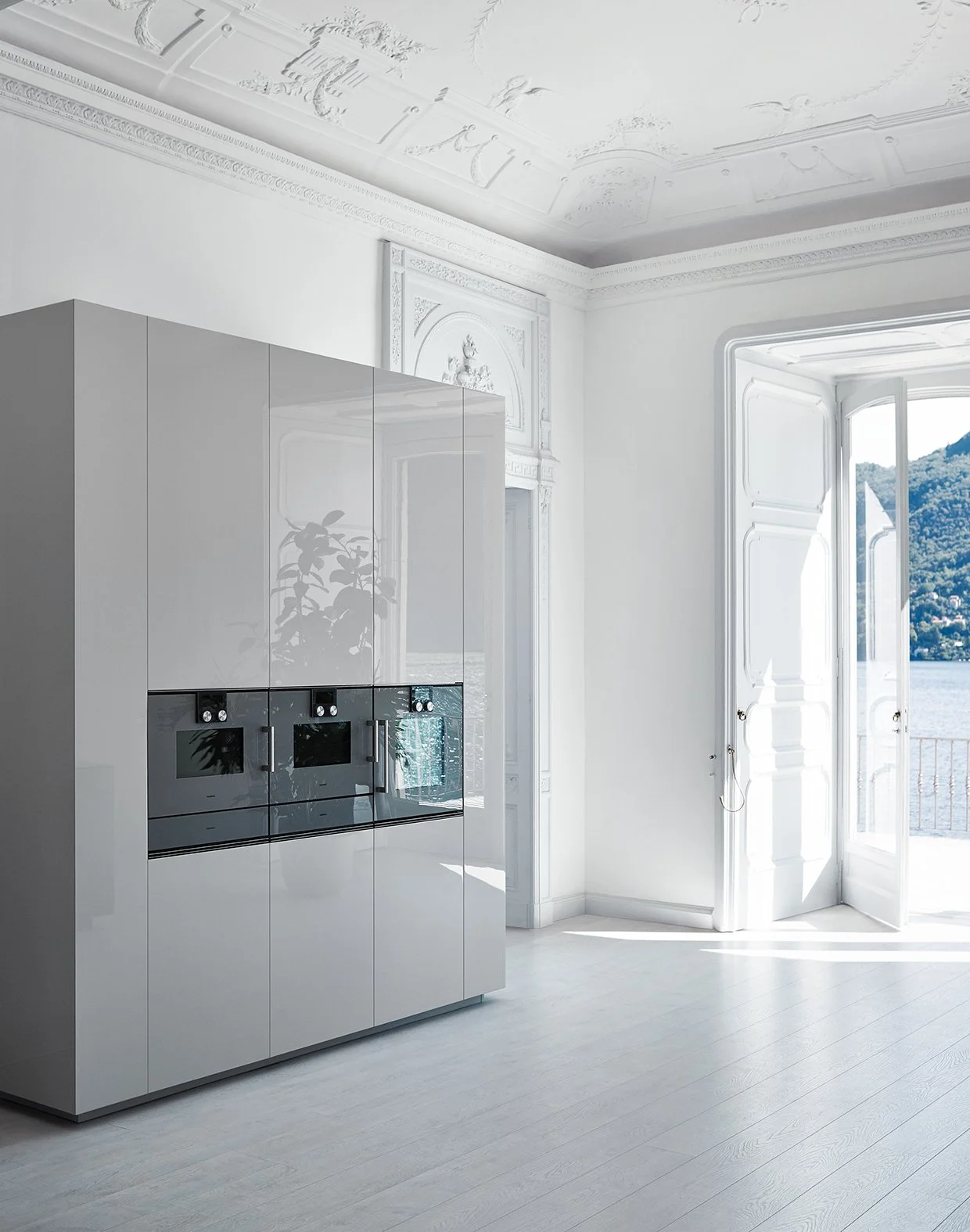 Helles, modernes Zimmer mit weißem Mobiliar, großer Fensteröffnung mit Blick auf Wasser und Berge, dekorative Wand- und Deckenverzierungen.