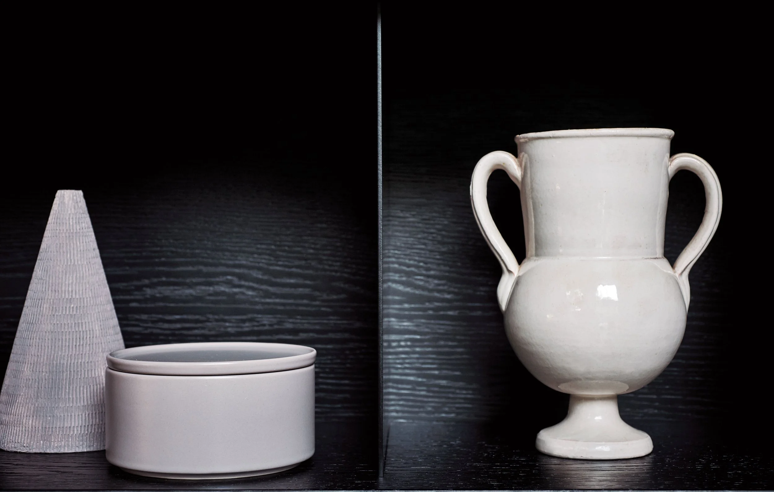 Vergleich von vier weißen Keramikartikeln auf schwarzem Hintergrund, von links nach rechts: eine konische Vase, eine Schüssel, eine kleine Schale und eine zweihändige Vase.