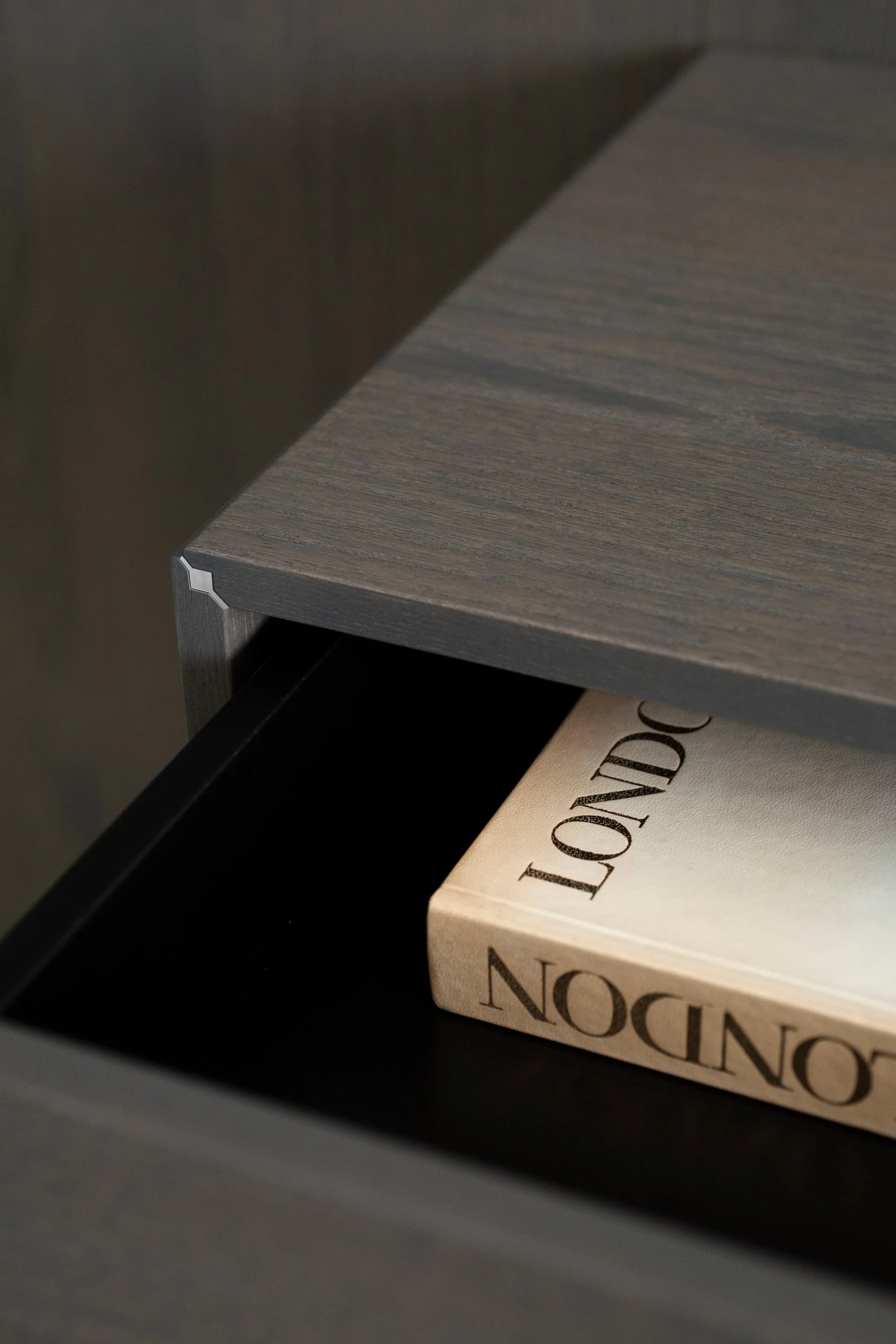 Nahaufnahme eines Buches mit dem Titel 'NOCION', das in einer Schublade liegt, und eine graue Holzplatte oder Tischoberfläche.