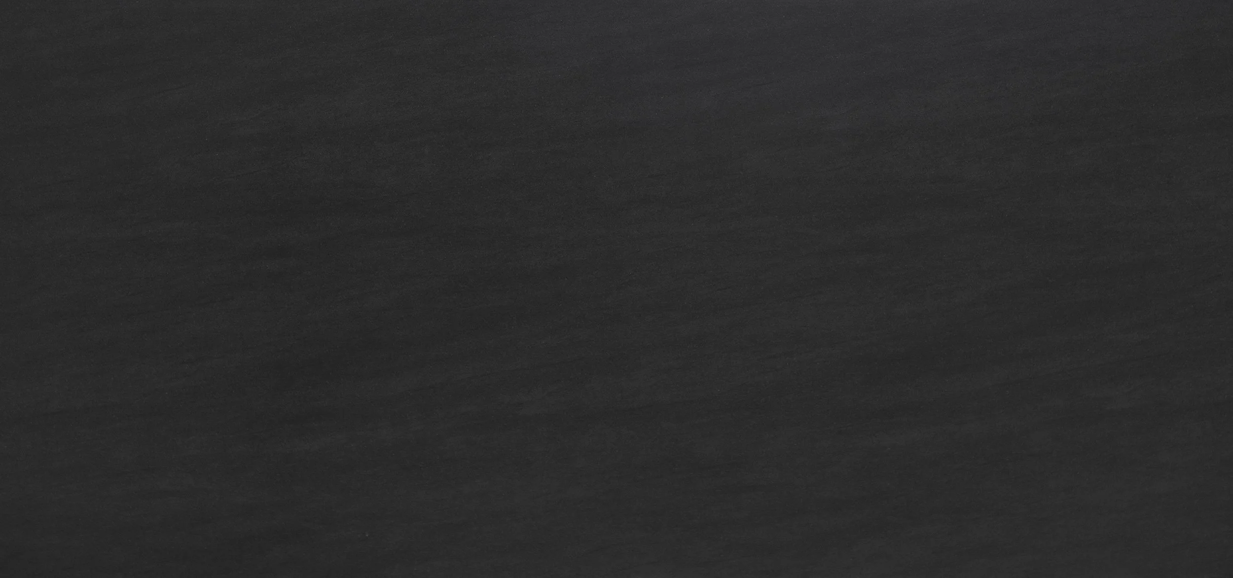 Das Bild zeigt eine dunkle Oberfläche, wahrscheinlich Holz oder eine ähnliche Textur.