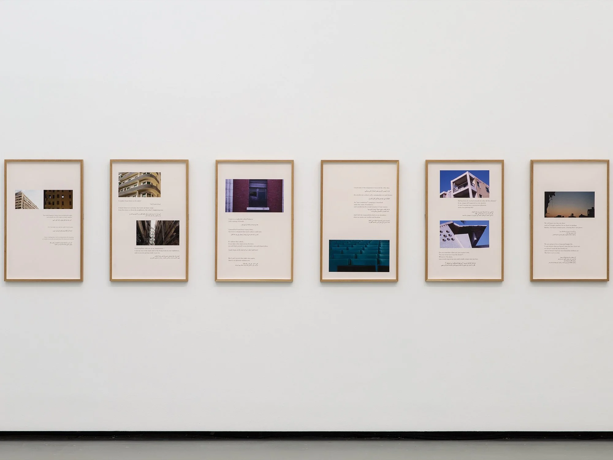 Six framed photo and text displays hung on a white gallery wall.