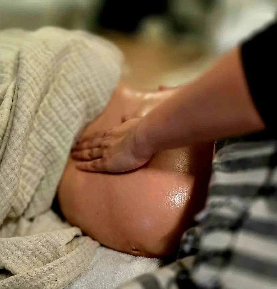 Massage du ventre d'une femme enceinte dans une ambiance sereine et apaisante
