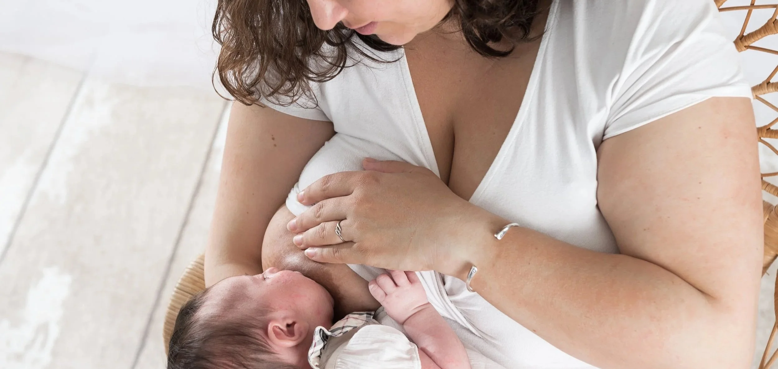 Nouveau-né réalisant sa première tétée d'accueil en peau à peau avec sa maman juste après la naissance.