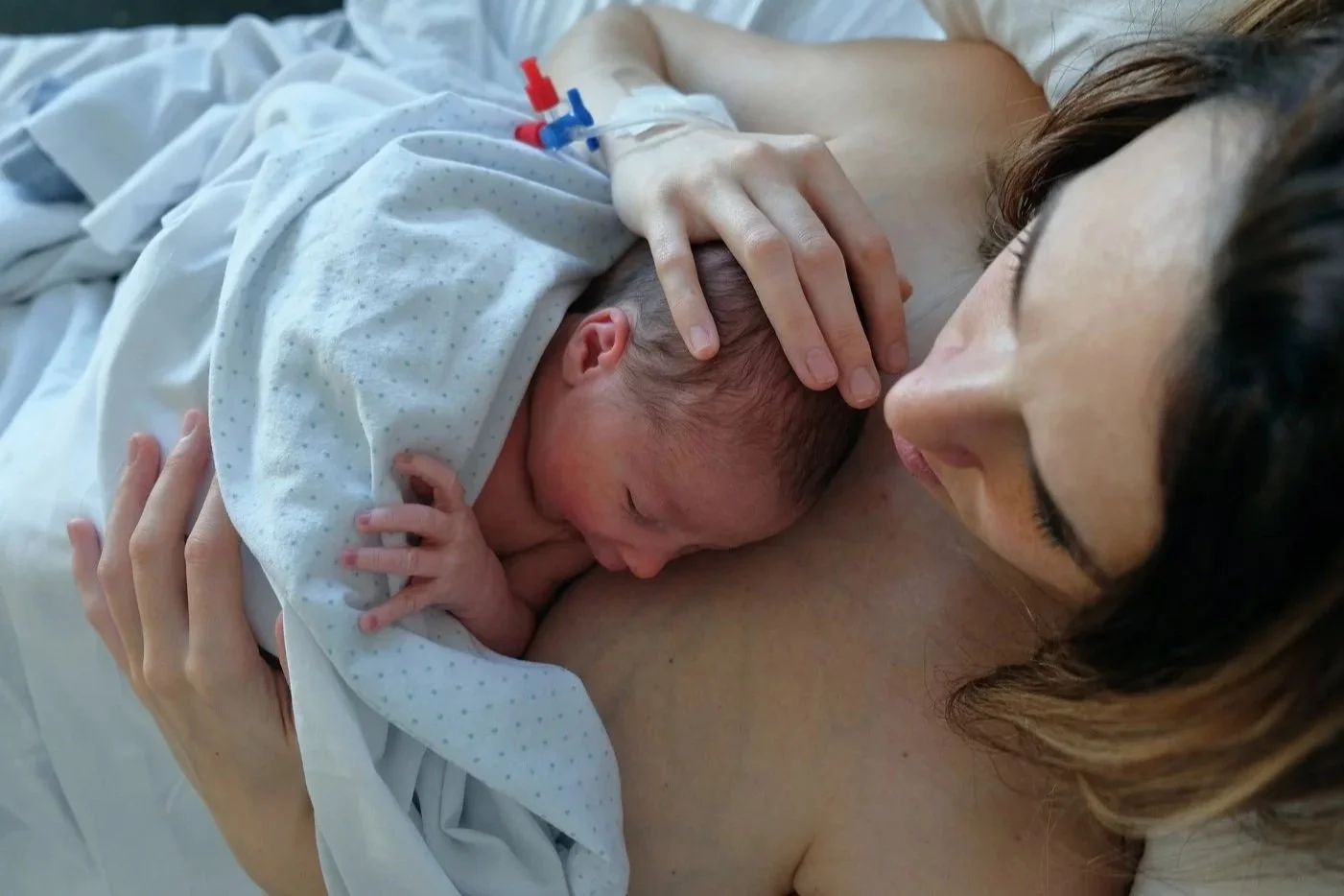 Maman tenant son nouveau-né en peau à peau juste après la naissance