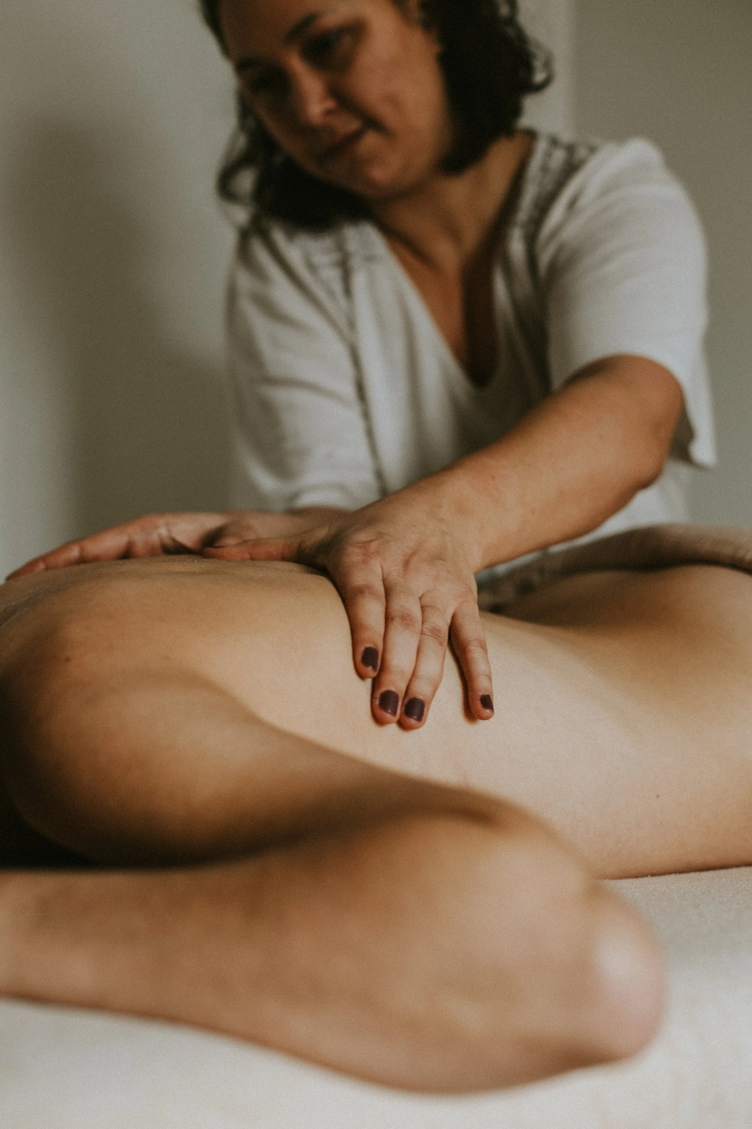 Une femme faites un massage à une personne allongée sur une table de massage à chevreuse dans les Yvelines