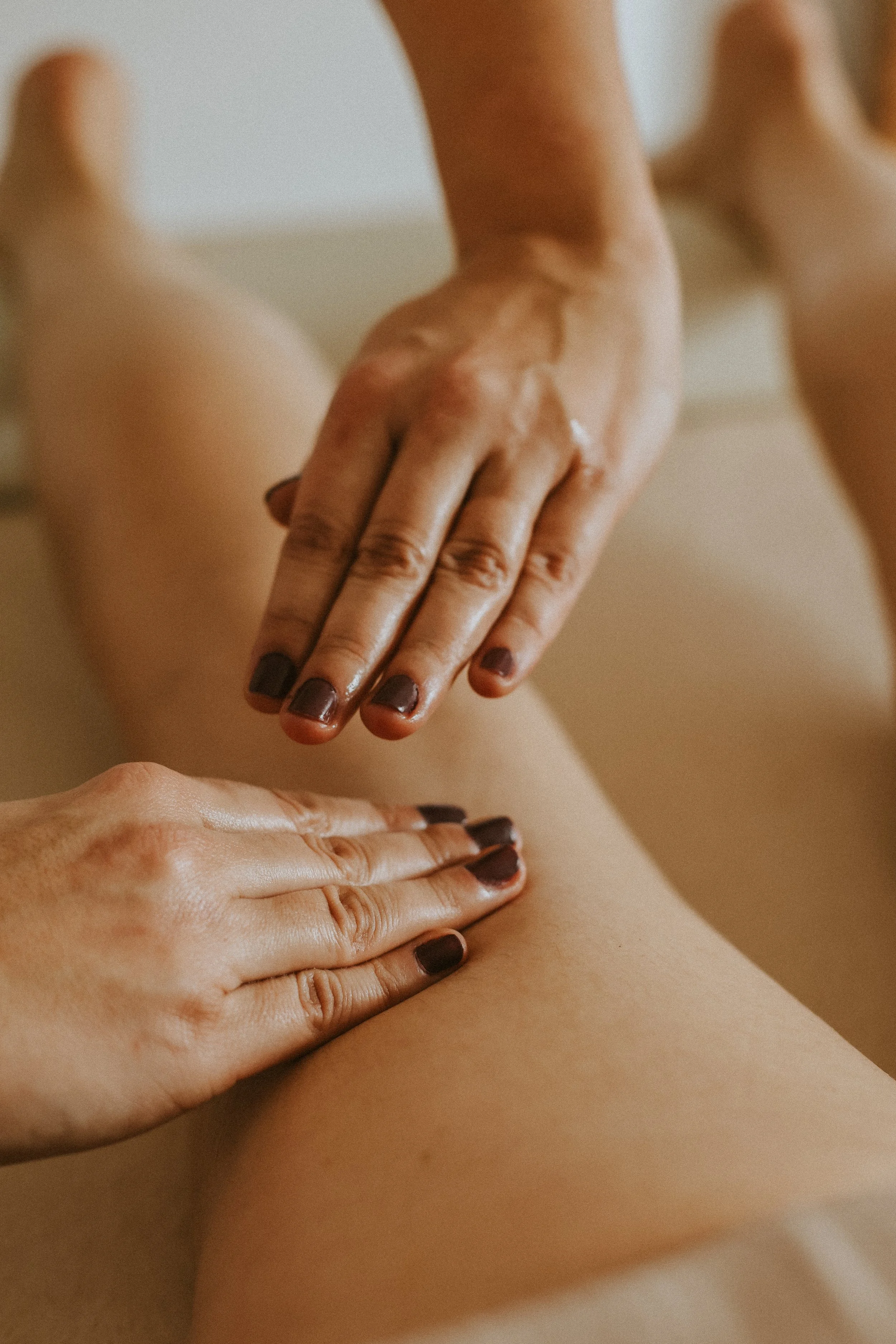 Massage tonique de l'arrière de la jambe d'une femme lors d'un massage bien-être post-partum en Essonne